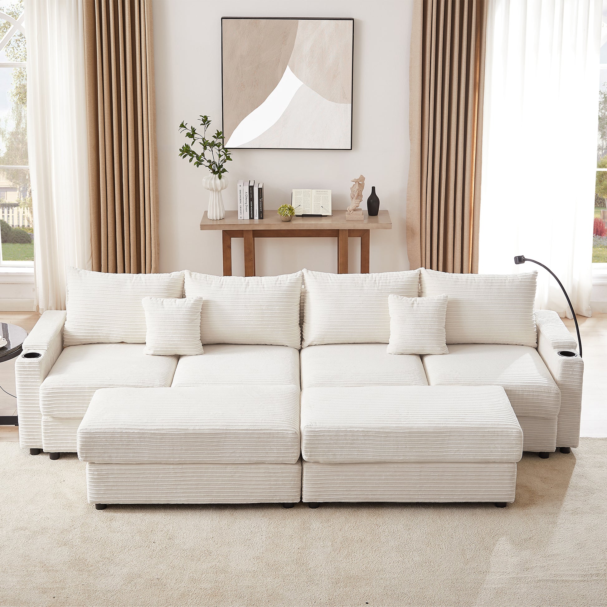 Plush cream corduroy sectional sofa with multiple throw pillows and an ottoman