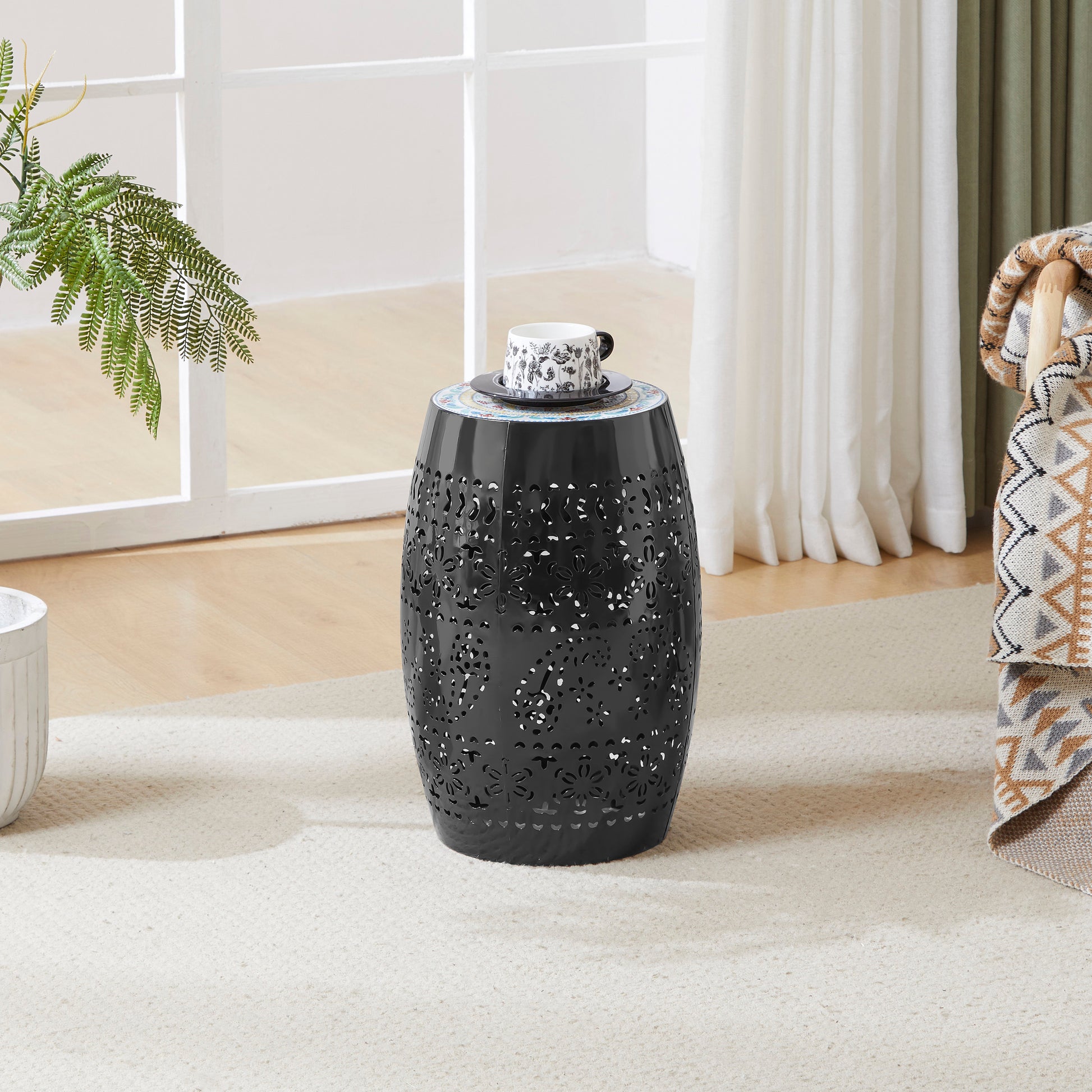 Black metal garden stool with intricate floral cutouts and mosaic top perfect for patio decor