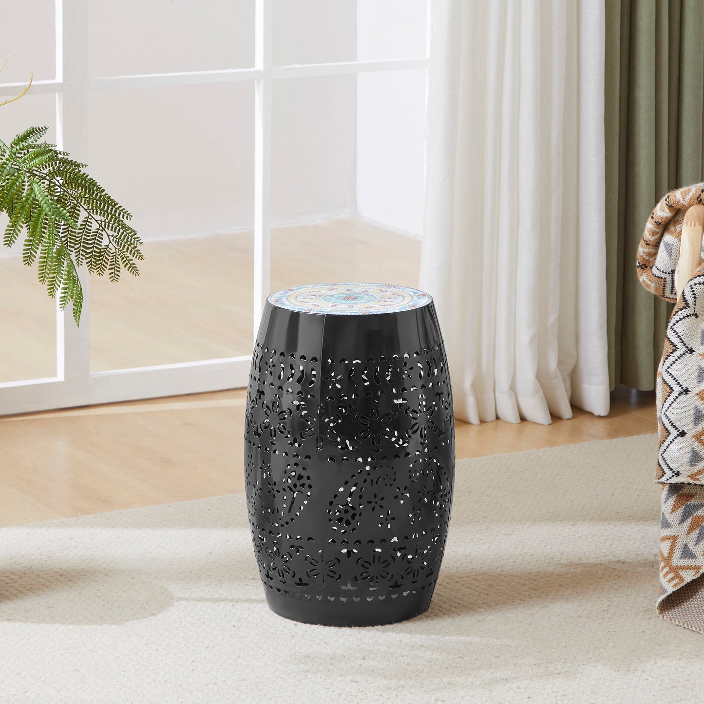 Black metal garden stool with intricate floral cutouts and a decorative mosaic top