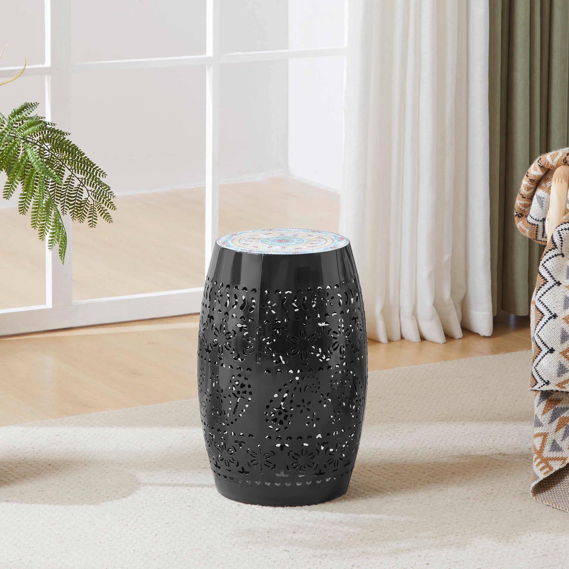 Black metal garden stool with intricate floral cutouts and a decorative mosaic top
