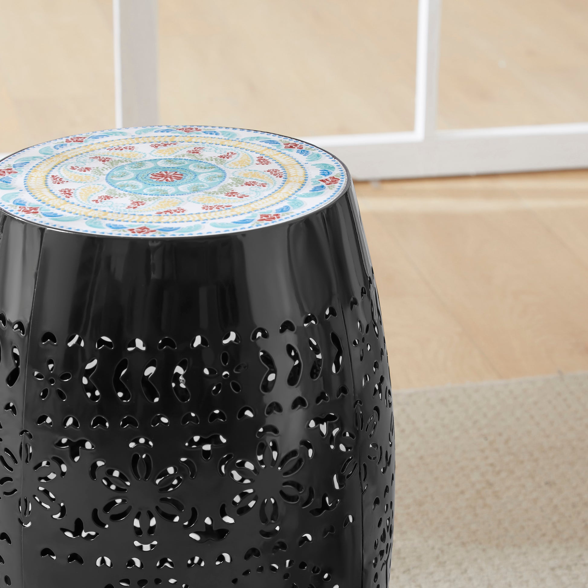 Black metal garden stool with ornate lasercut floral pattern and mandala top