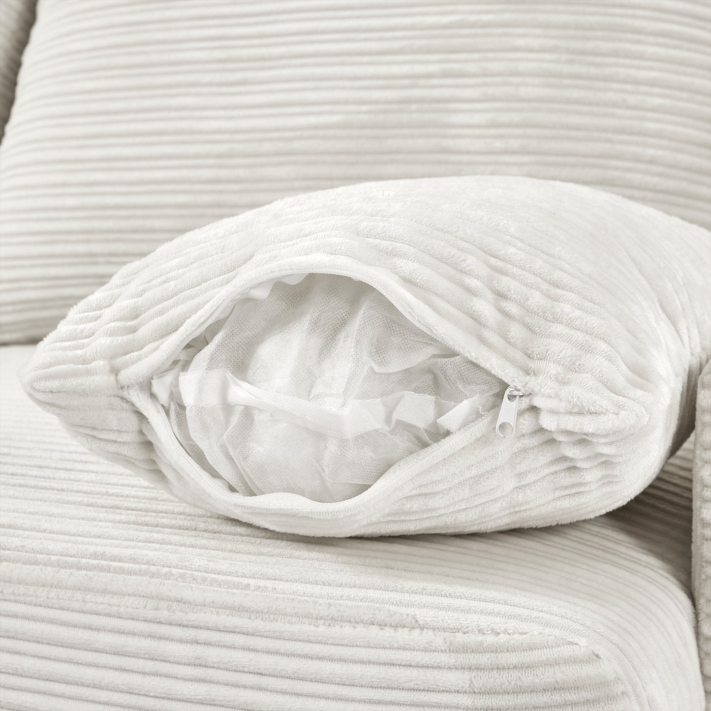 Cream corduroy throw pillow with visible zipper revealing soft fill