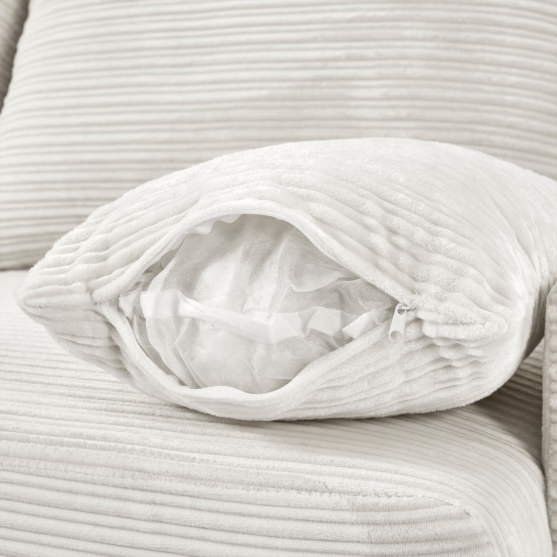 Cream corduroy throw pillow with visible zipper revealing soft fill