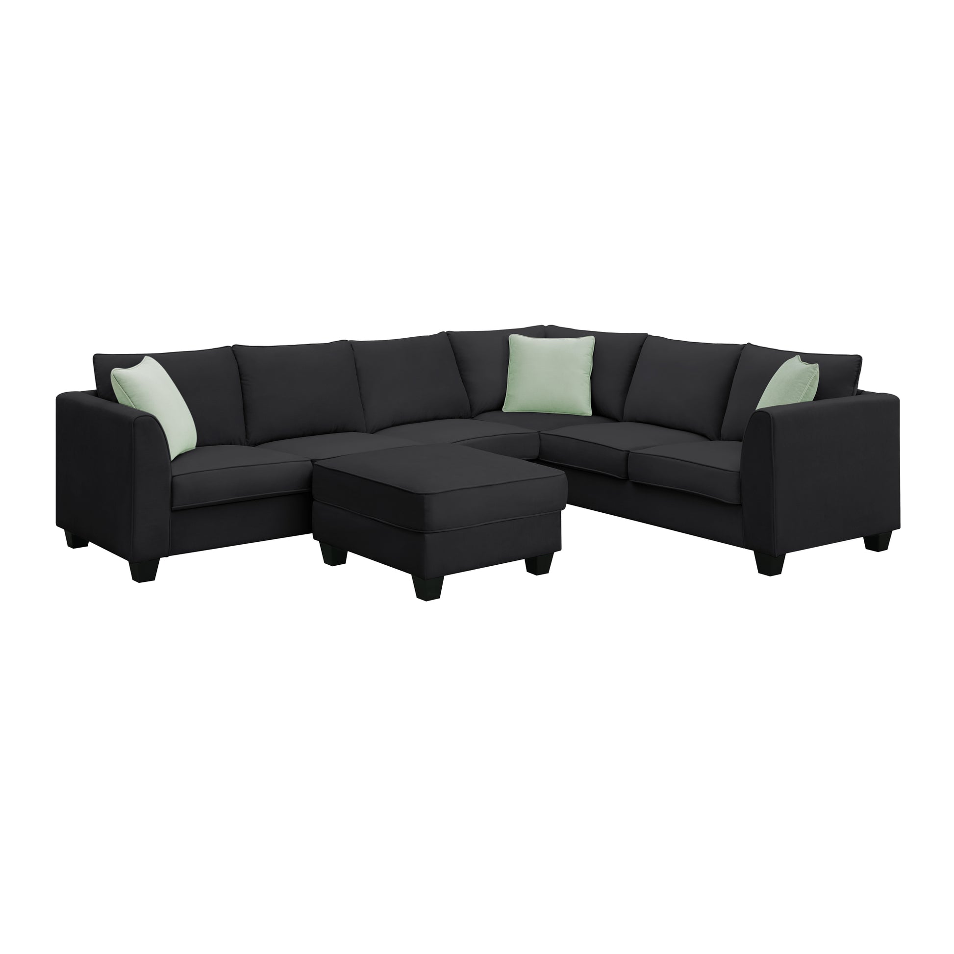 Dark grey fabric sectional sofa with three light green accent pillows and ottoman