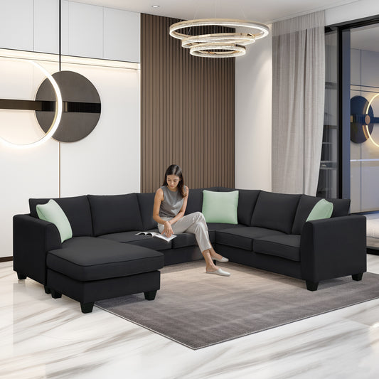 Dark grey fabric sectional sofa with light green accent pillows and chaise