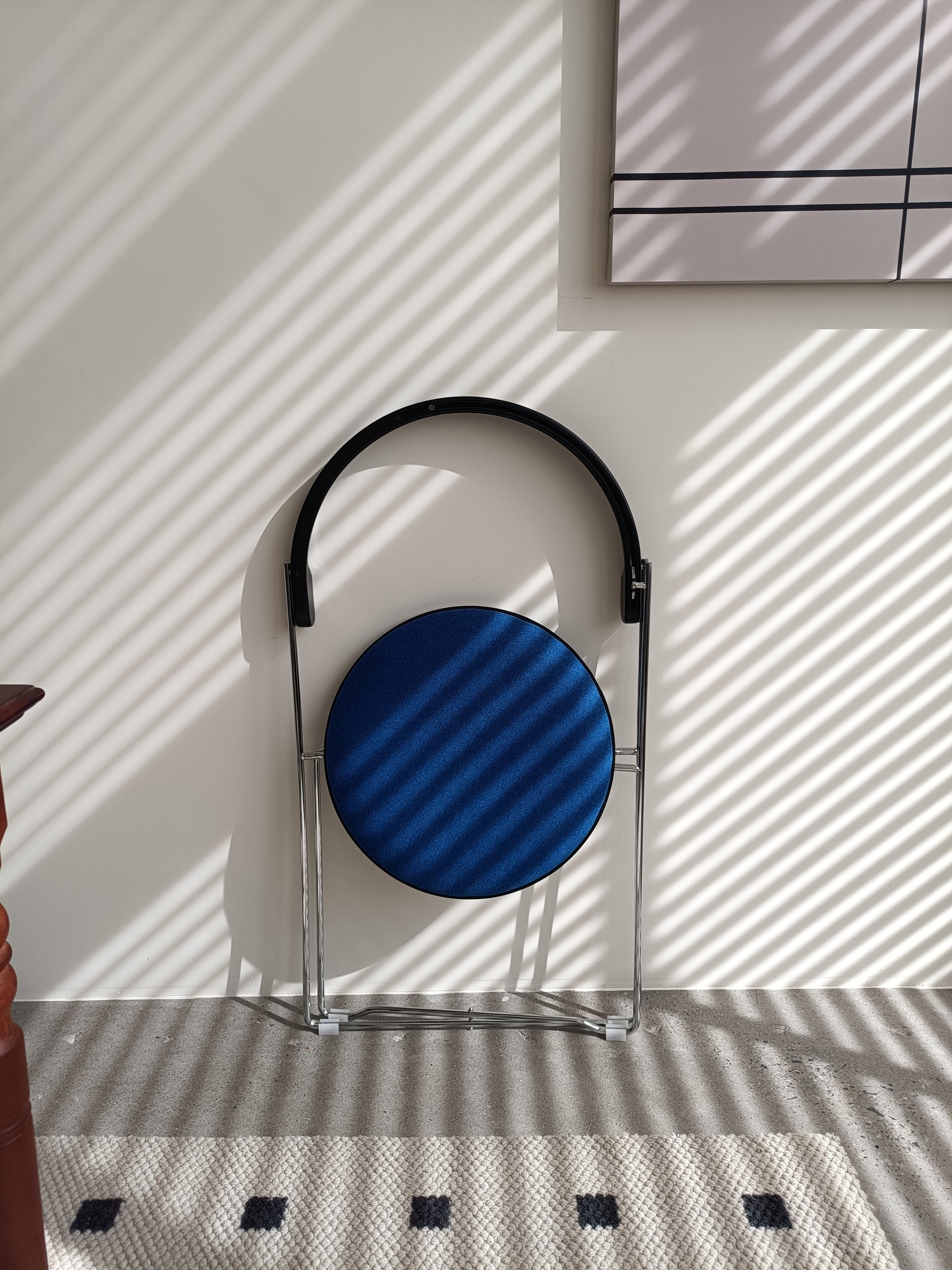 Sleek blue round seat folding chair with chrome frame and black handle