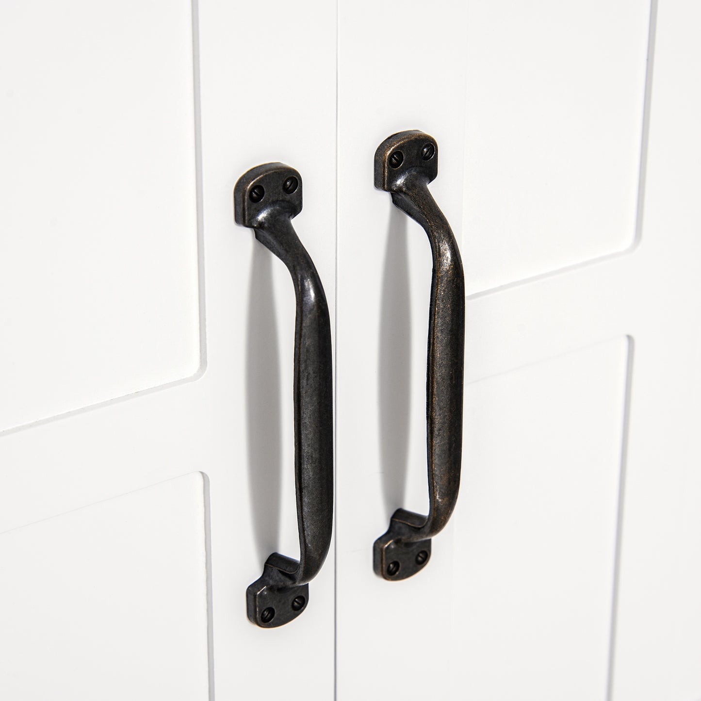 Rustic dark bronze cabinet pulls with mounting screws on white door
