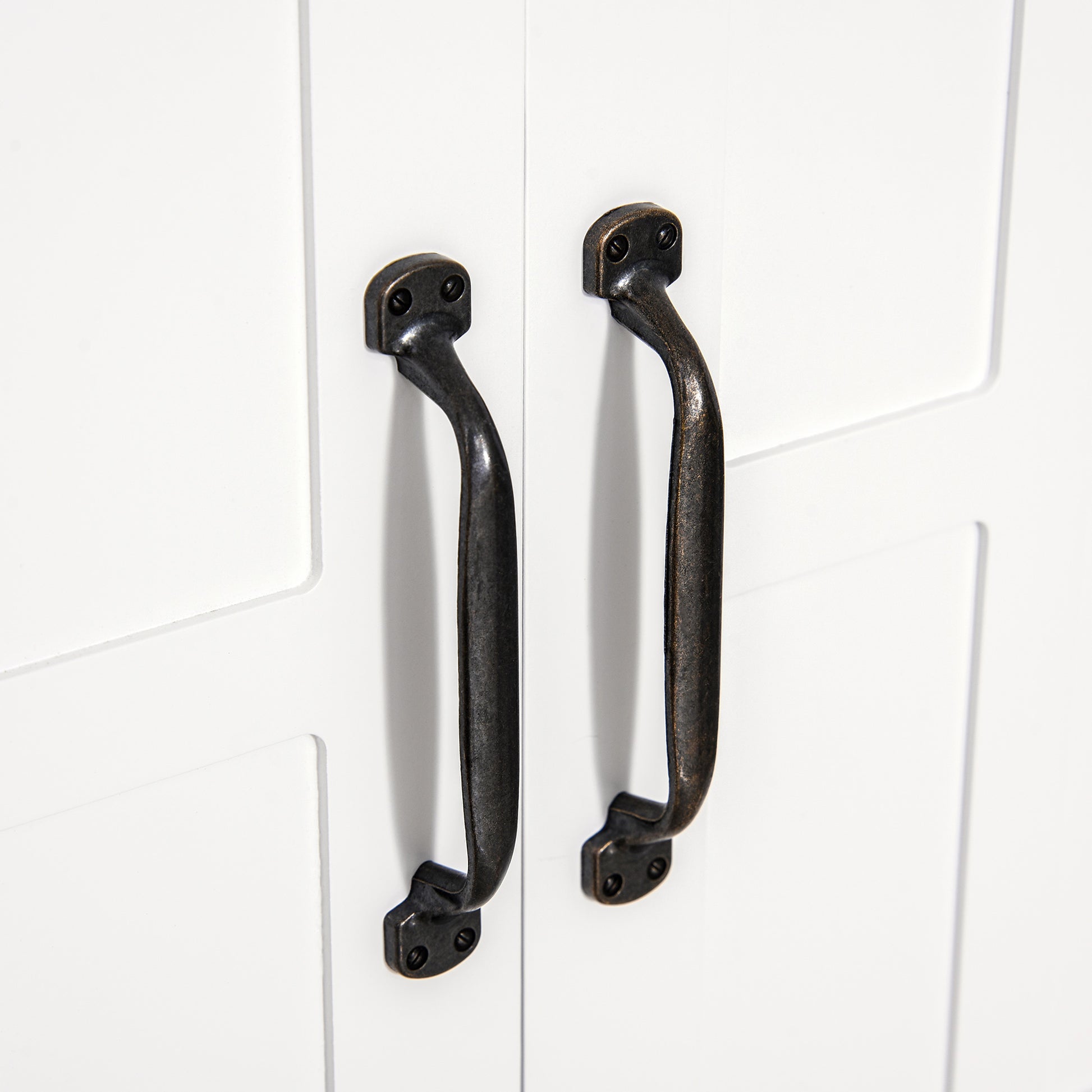 Rustic dark bronze cabinet pulls with mounting screws on white door