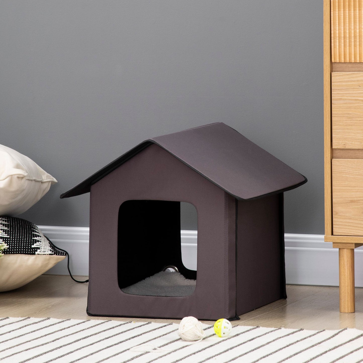 Dark grey fabric cat house with plush bedding and playful cat toys
