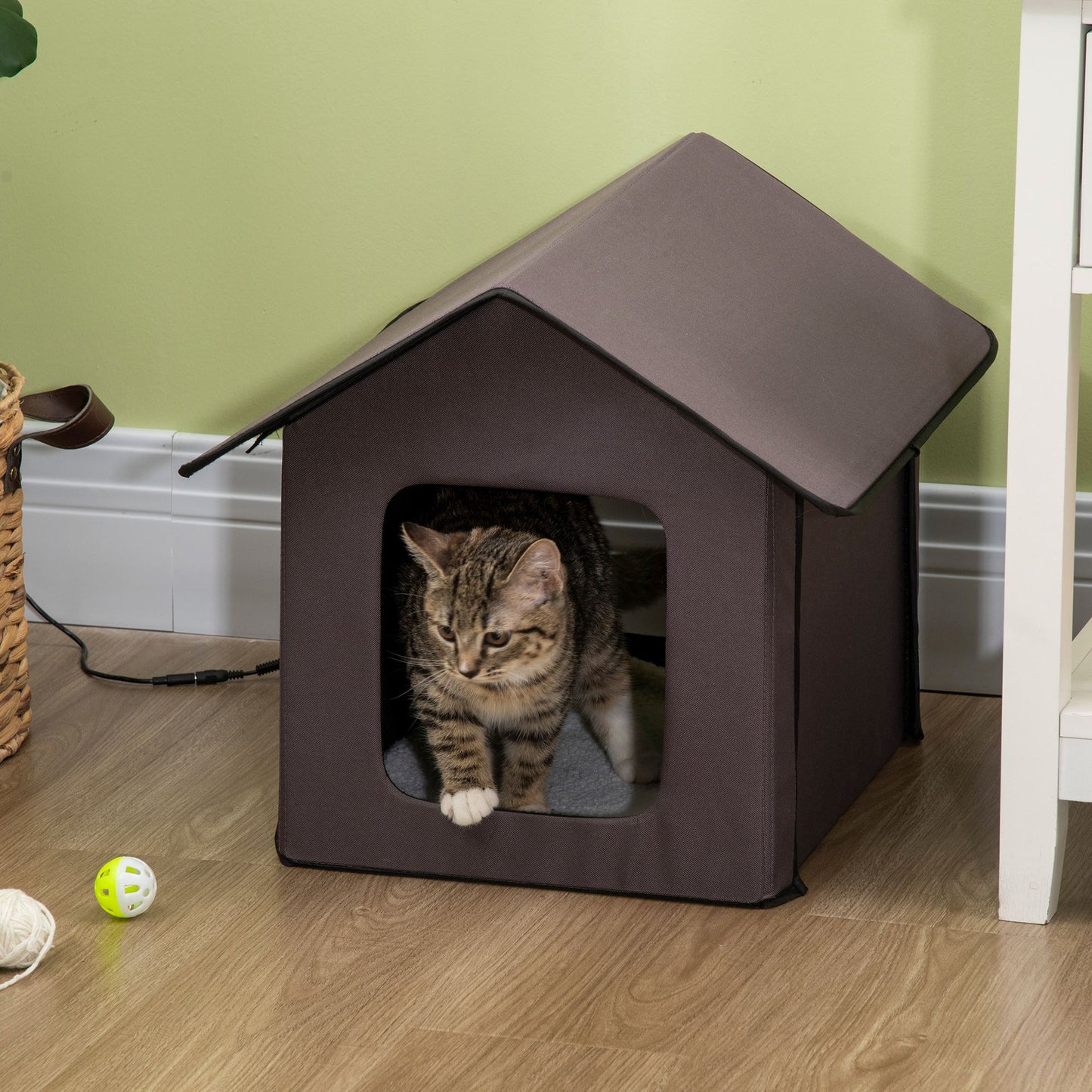 Brown fabric cat house with a tabby cat emerging
