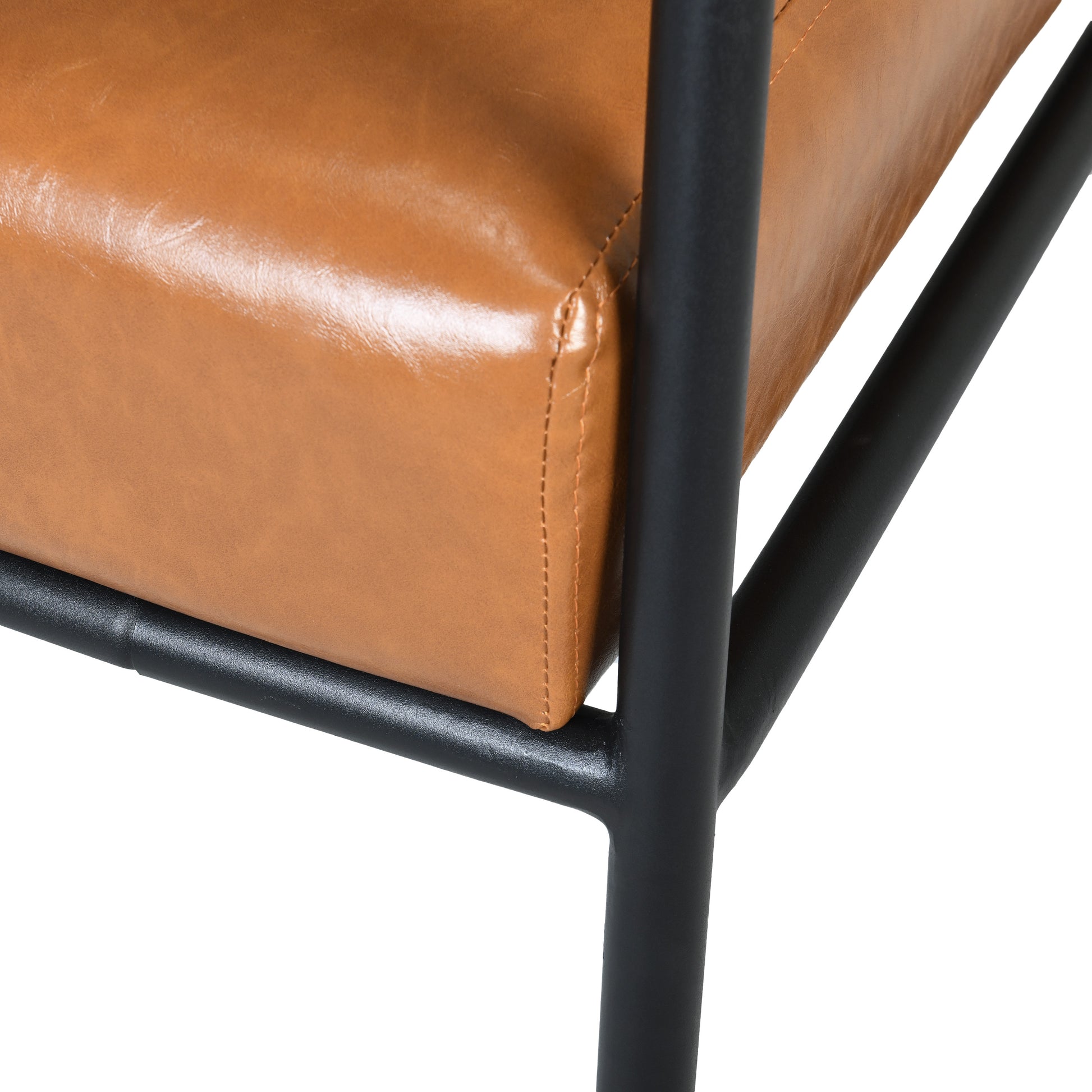 Closeup of a rich tan faux leather armchair cushion with visible stitching and a matte black metal frame