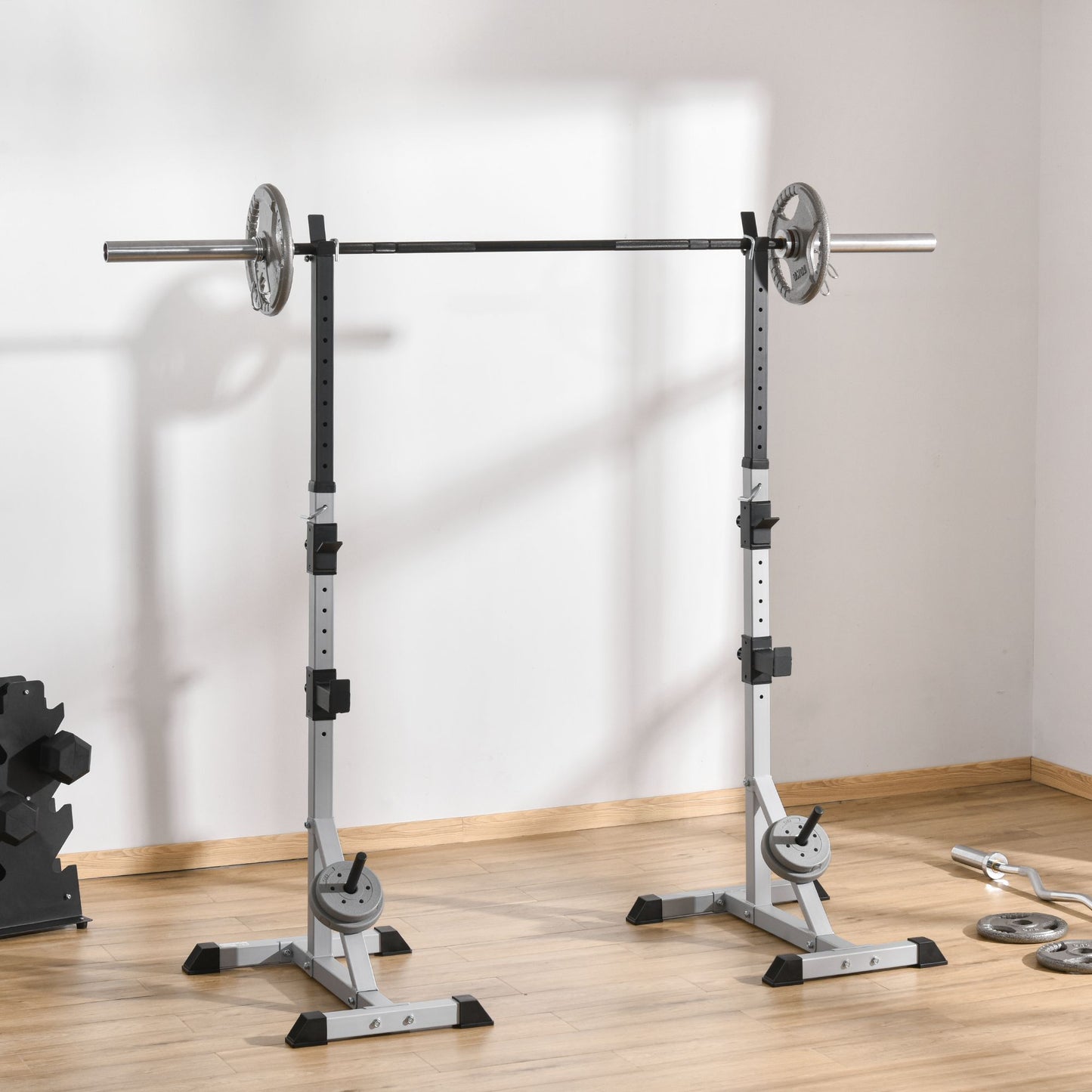 Adjustable squat rack in gray with a barbell and weight plates ideal for home gyms