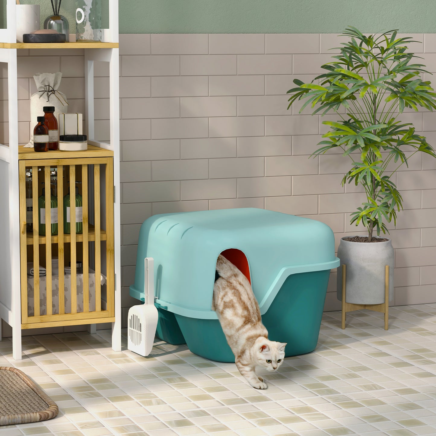 Teal hooded cat litter box with a white scoop and a tabby cat exiting