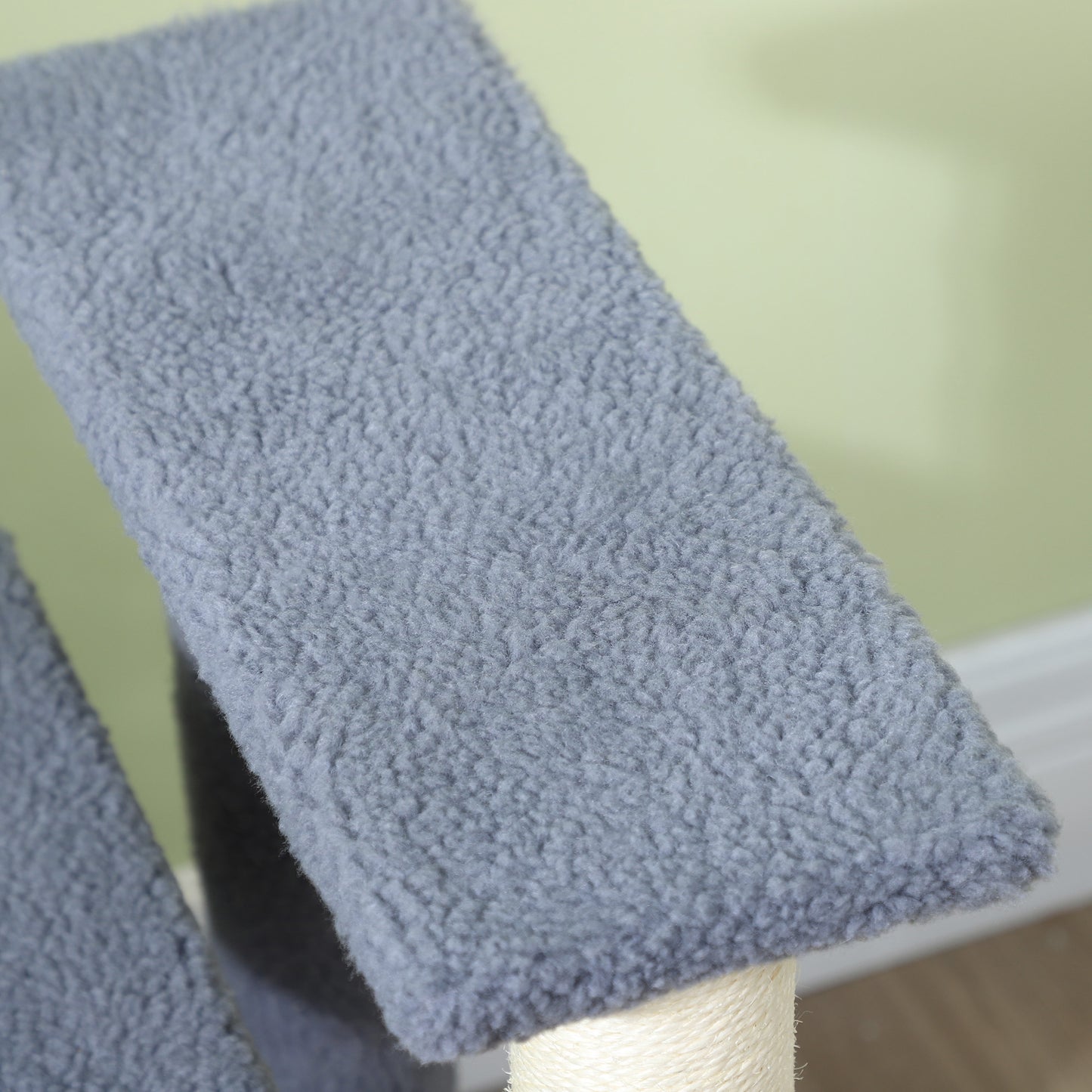 Closeup of a grey fluffy fabric platform on a cat tree scratching post