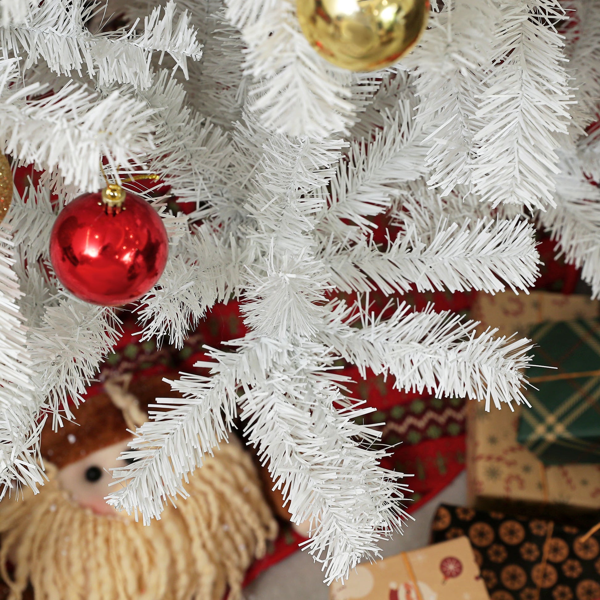 White artificial Christmas tree branch with red ornament festive holiday decor
