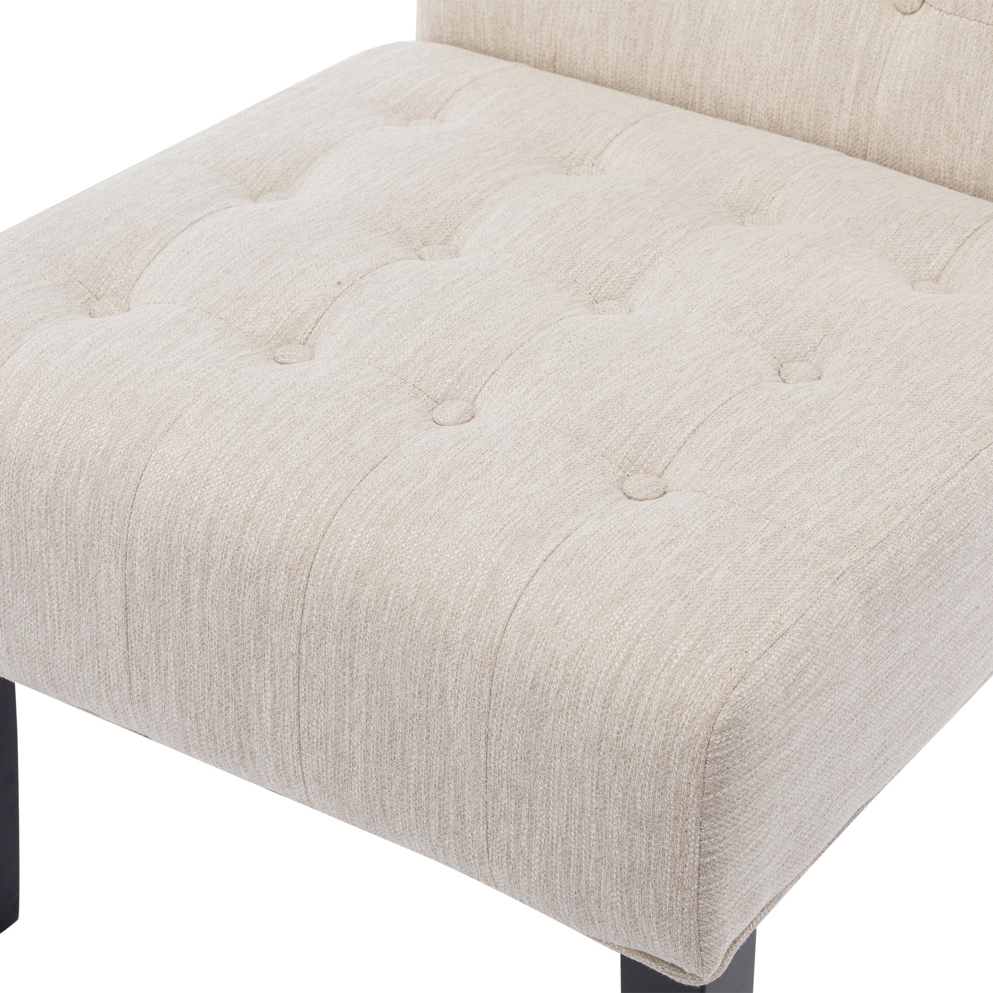 Beige linen upholstered armchair with deep button tufting and dark metal legs