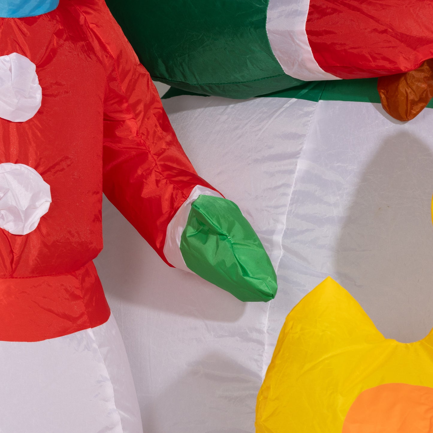 Red and white inflatable snowman arm with green glove detail for festive decor