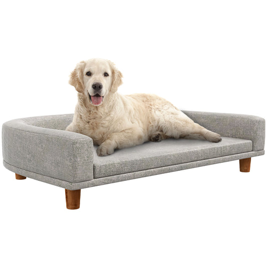 Golden Retriever dog relaxing on a plush grey tufted dog bed with wooden legs