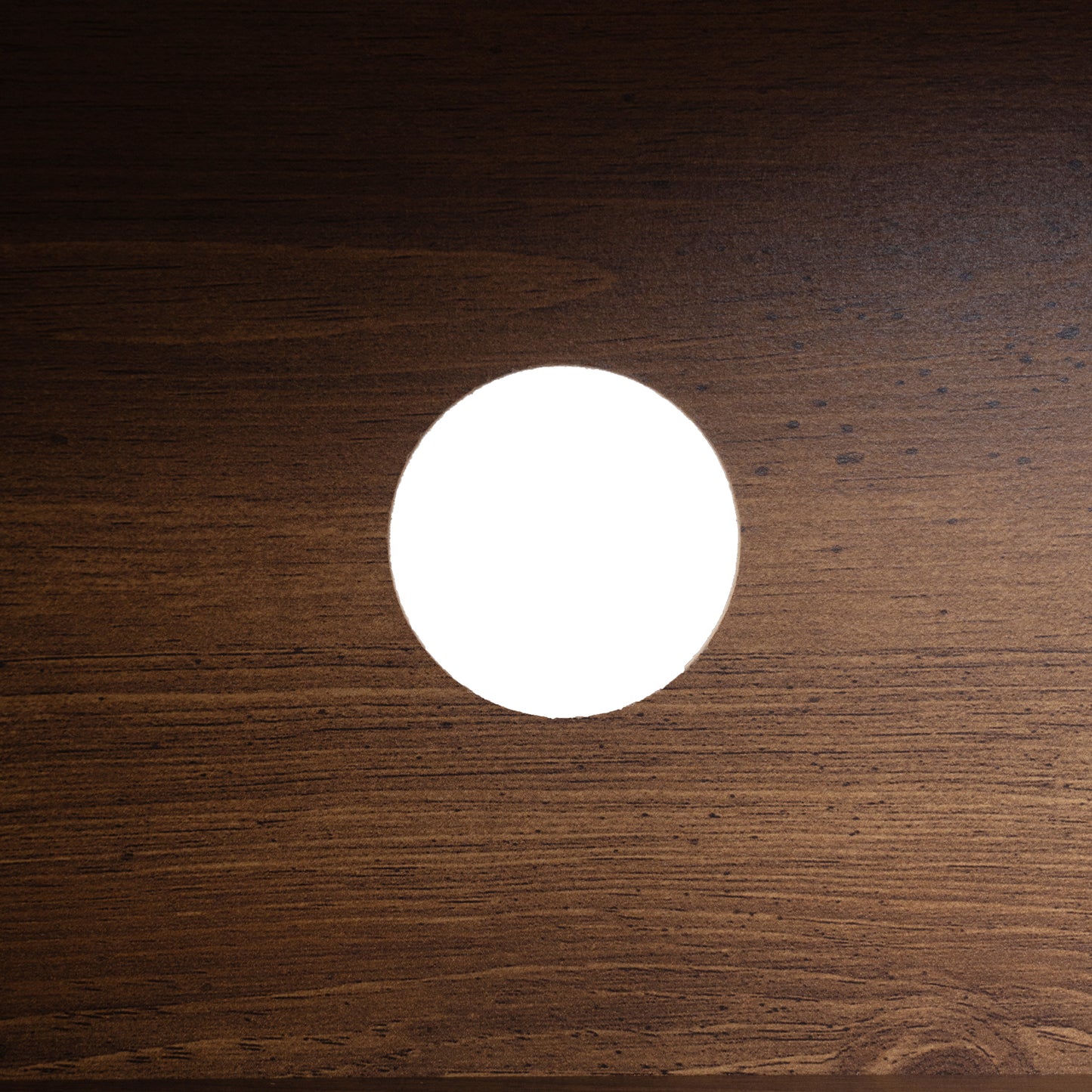 Dark wood grain texture with a circular cutout showing white light perfect for a modern desk