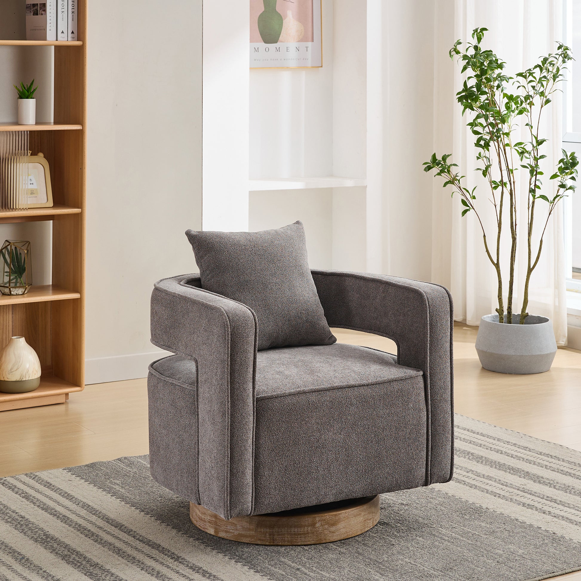 Gray upholstered accent chair with swivel base and throw pillow