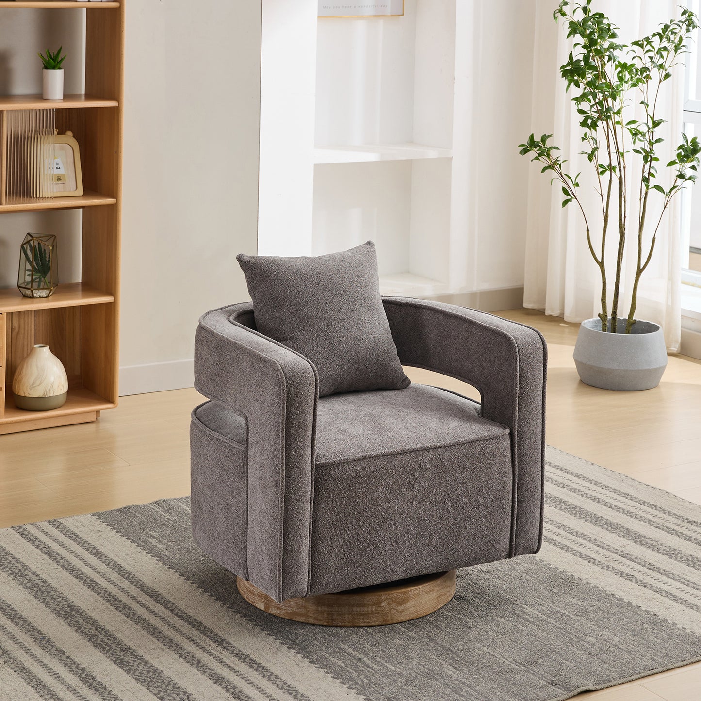 Modern grey upholstered swivel chair with a comfortable accent pillow