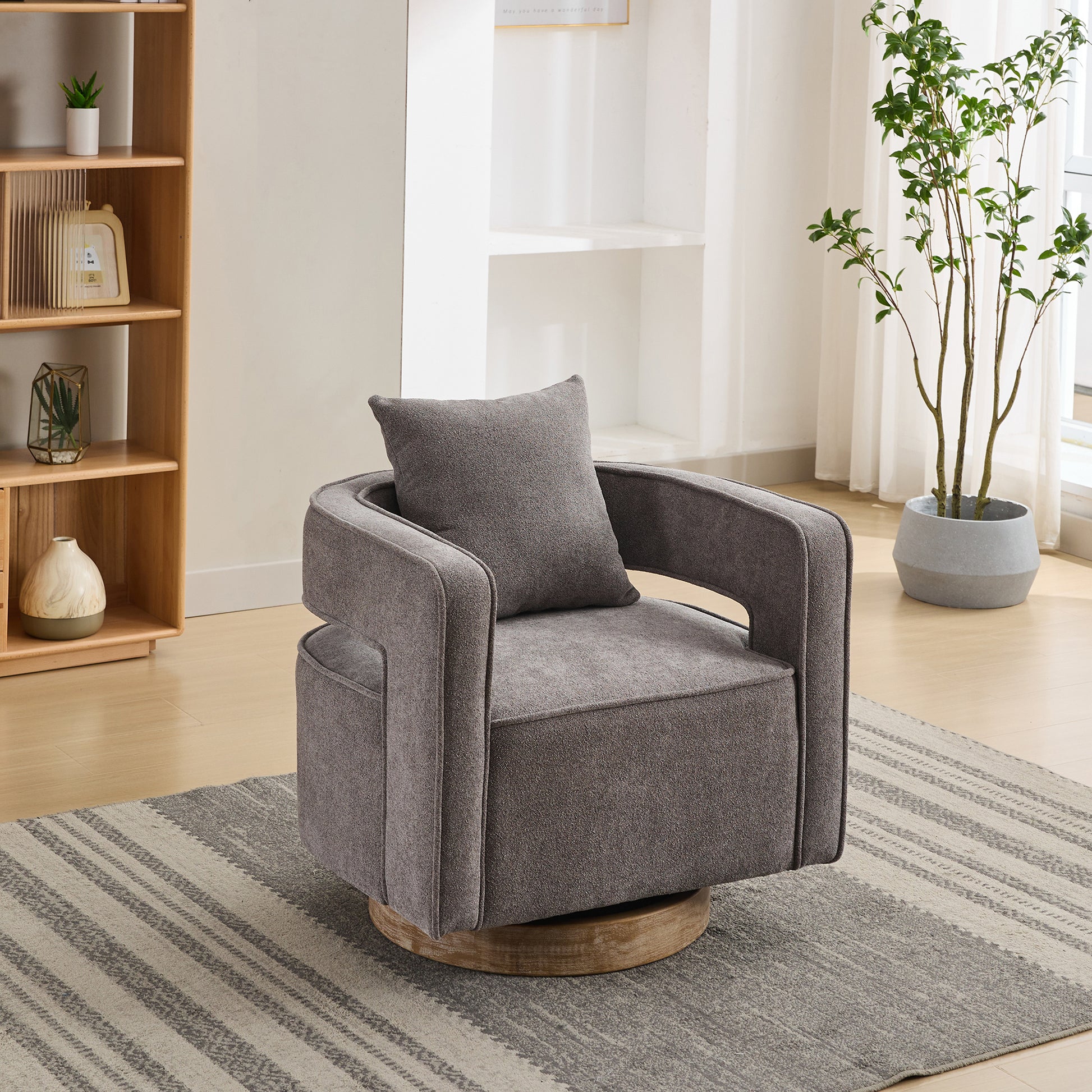 Modern grey upholstered swivel chair with a comfortable accent pillow