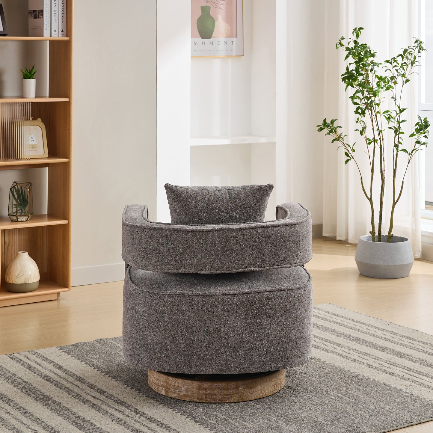 Textured grey swivel accent chair with wooden base and included pillow