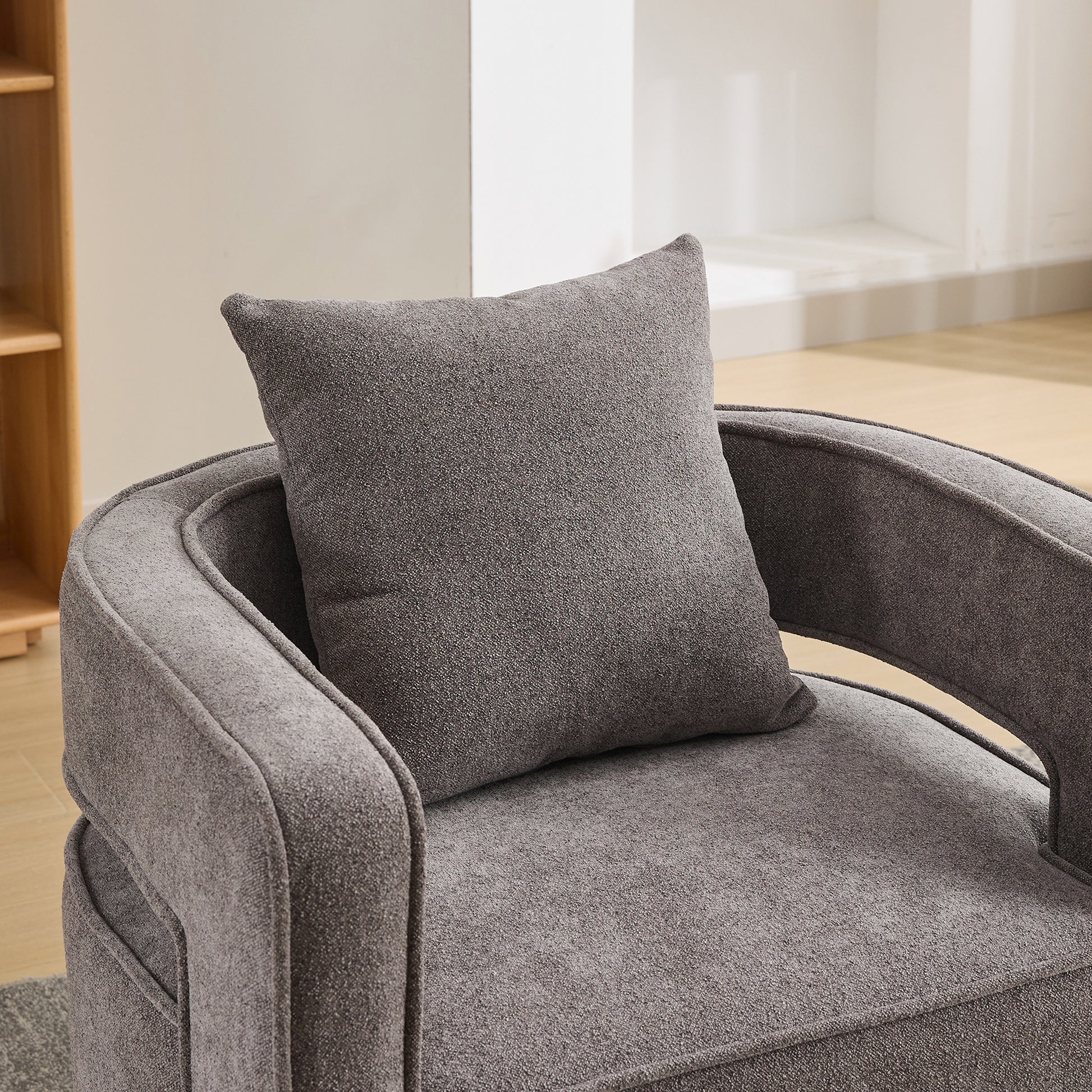 Plush gray accent chair with textured fabric and matching throw pillow