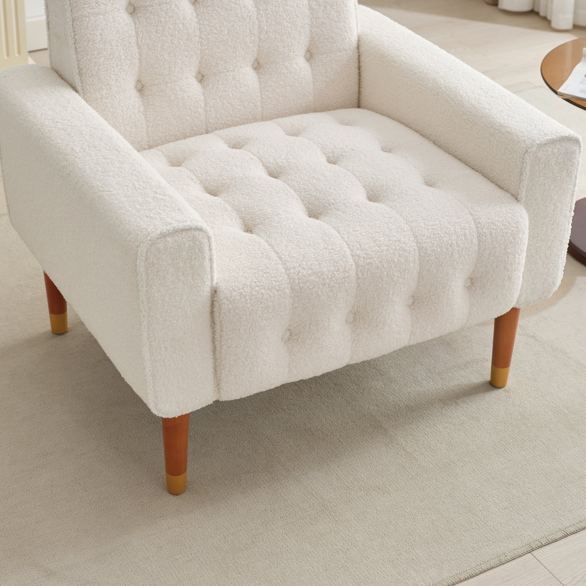 Cream boucle armchair with tufted seat and wooden legs for cozy living room seating