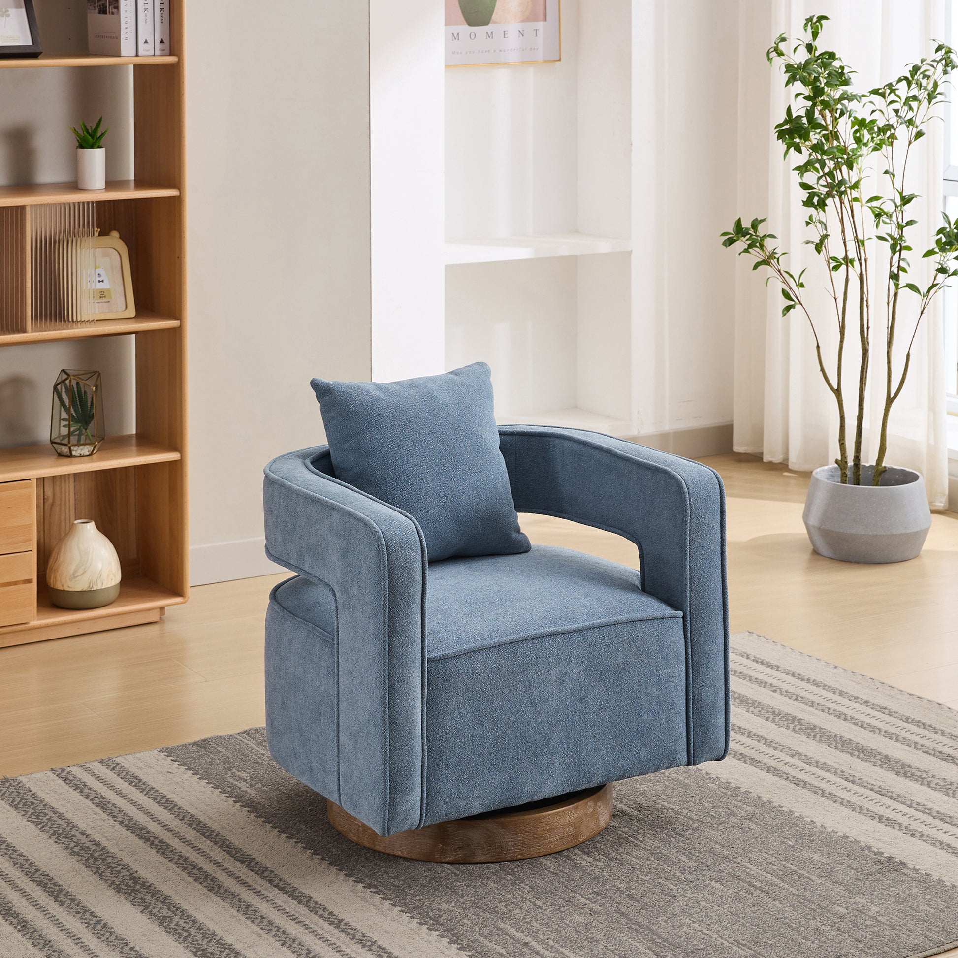 Blue fabric accent chair with wooden swivel base and matching pillow