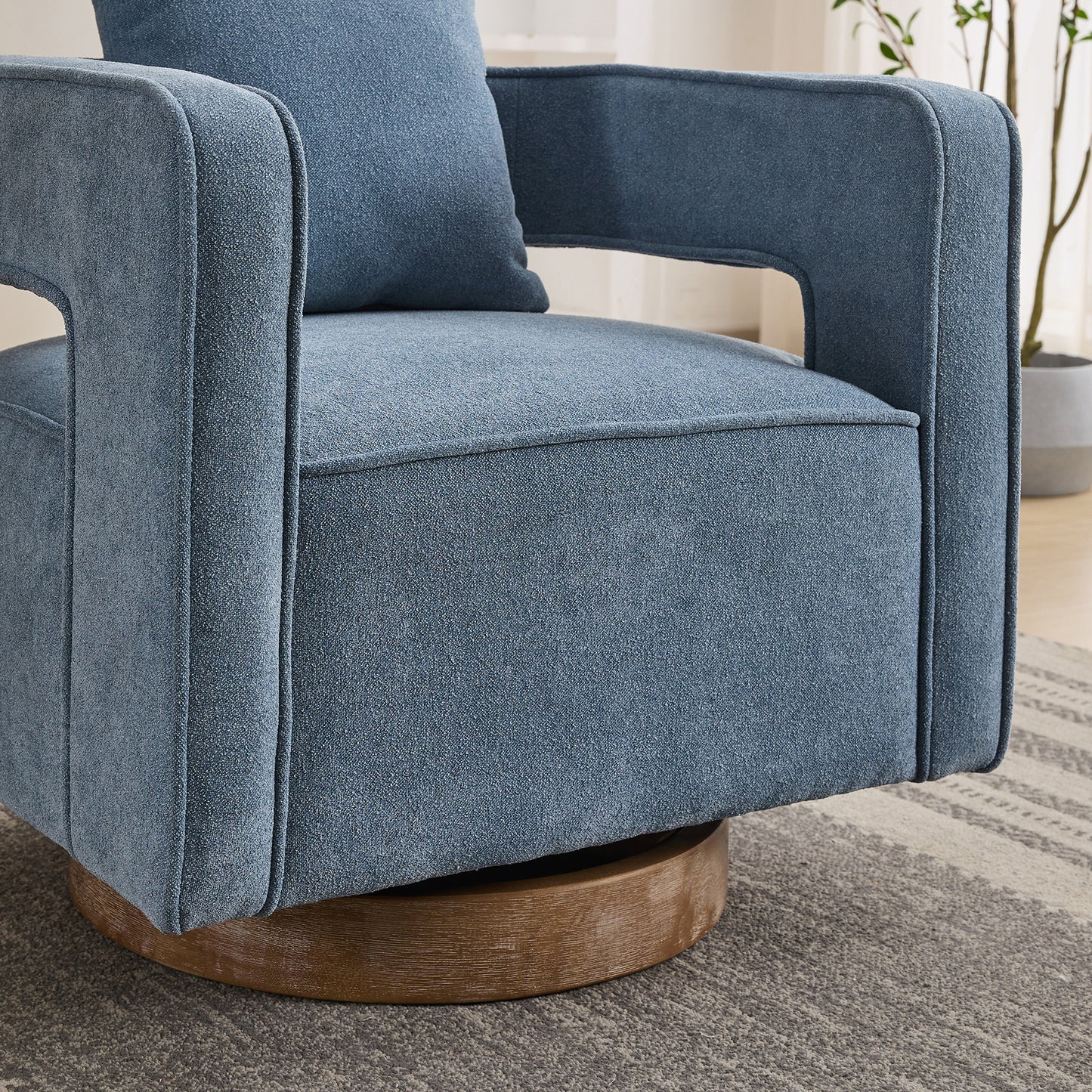 Blue upholstered swivel armchair with clean lines and a wooden base