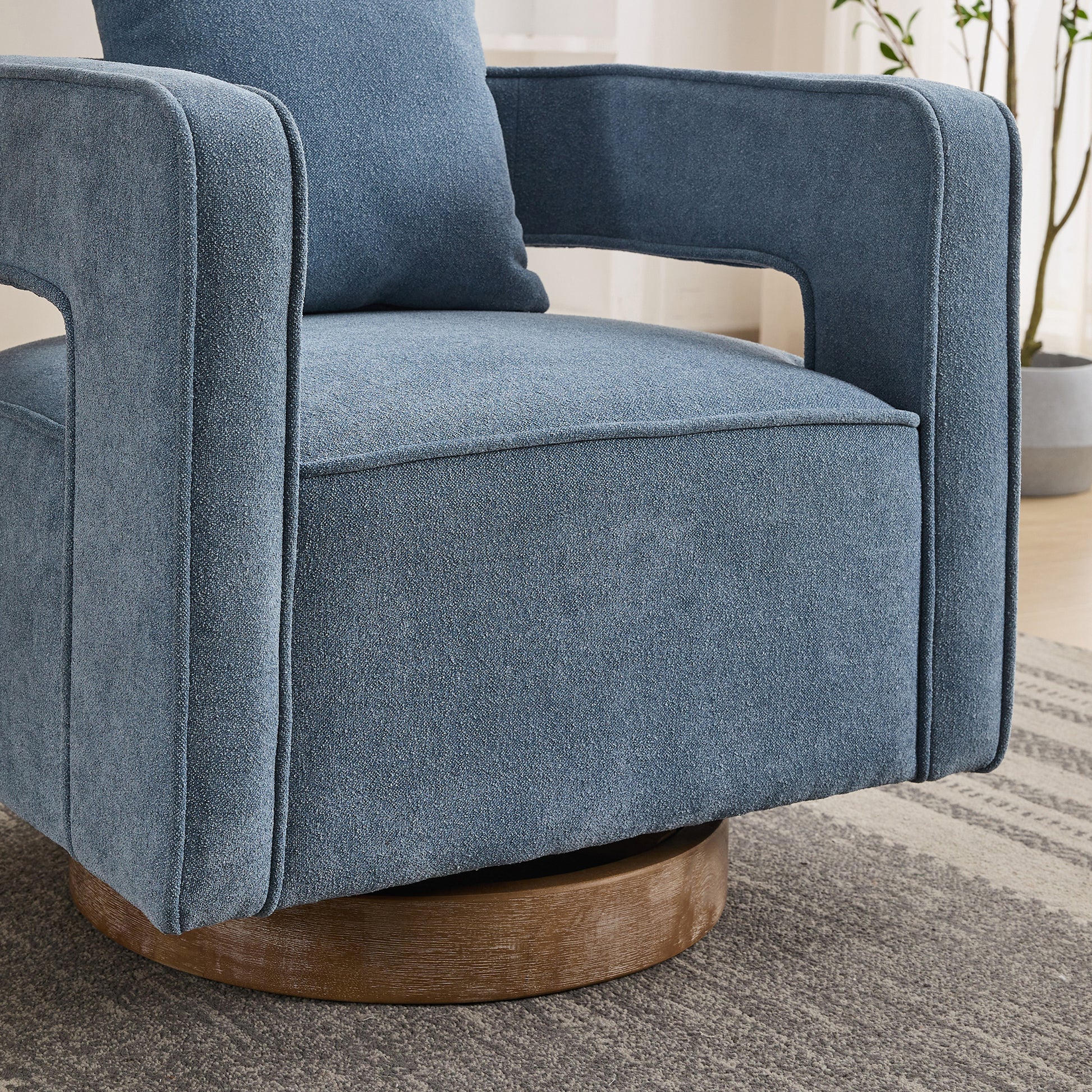 Blue upholstered swivel armchair with clean lines and a wooden base