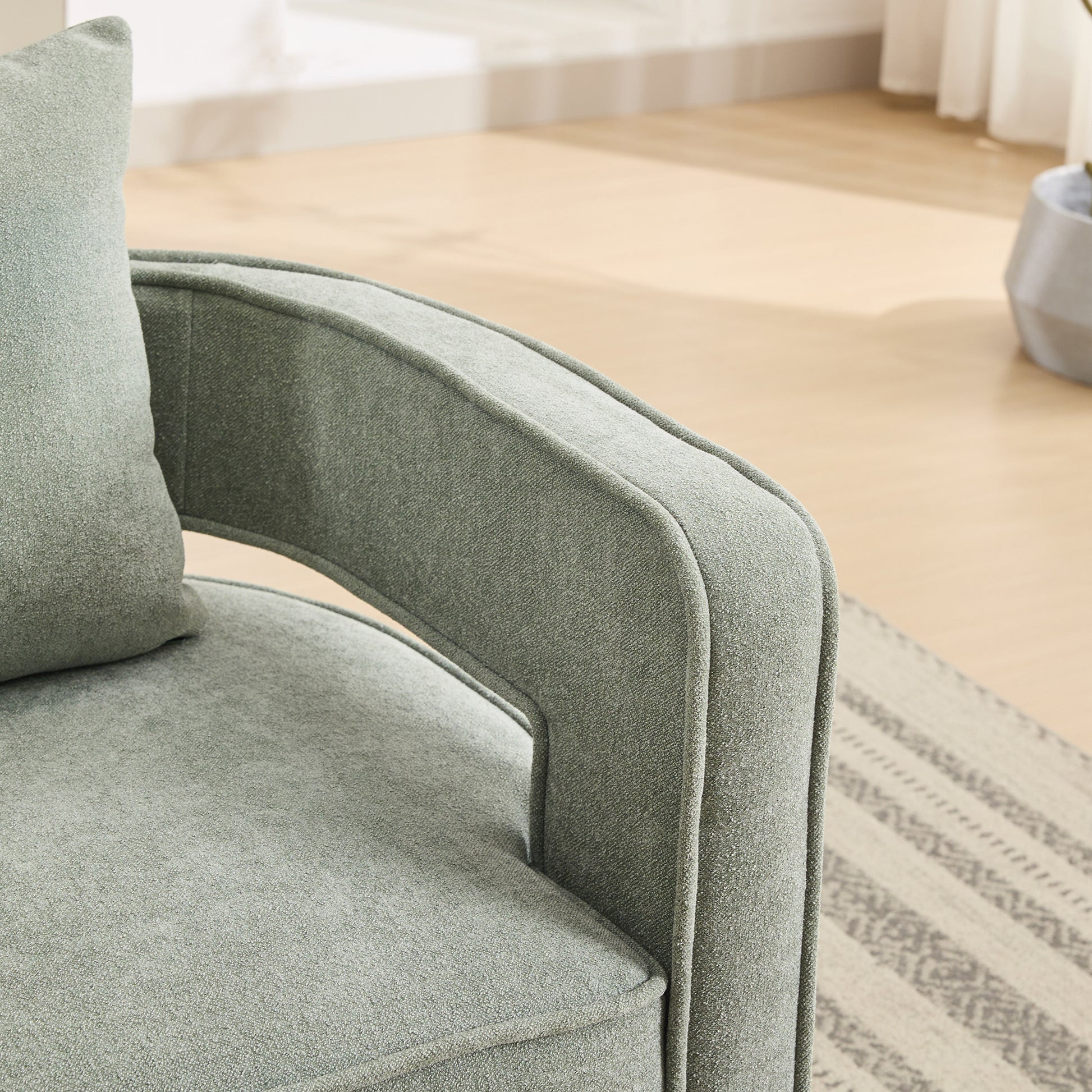 Sage green textured fabric armchair with plush cushion and modern frame