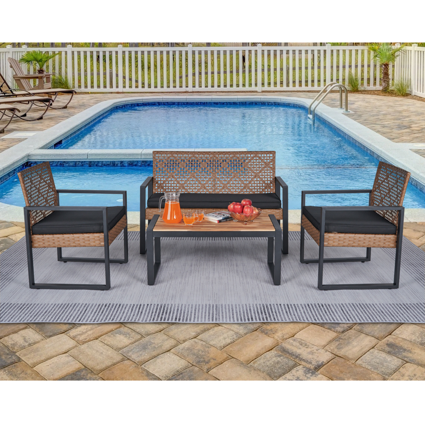 Wicker patio set with black cushions including two chairs a loveseat and a coffee table