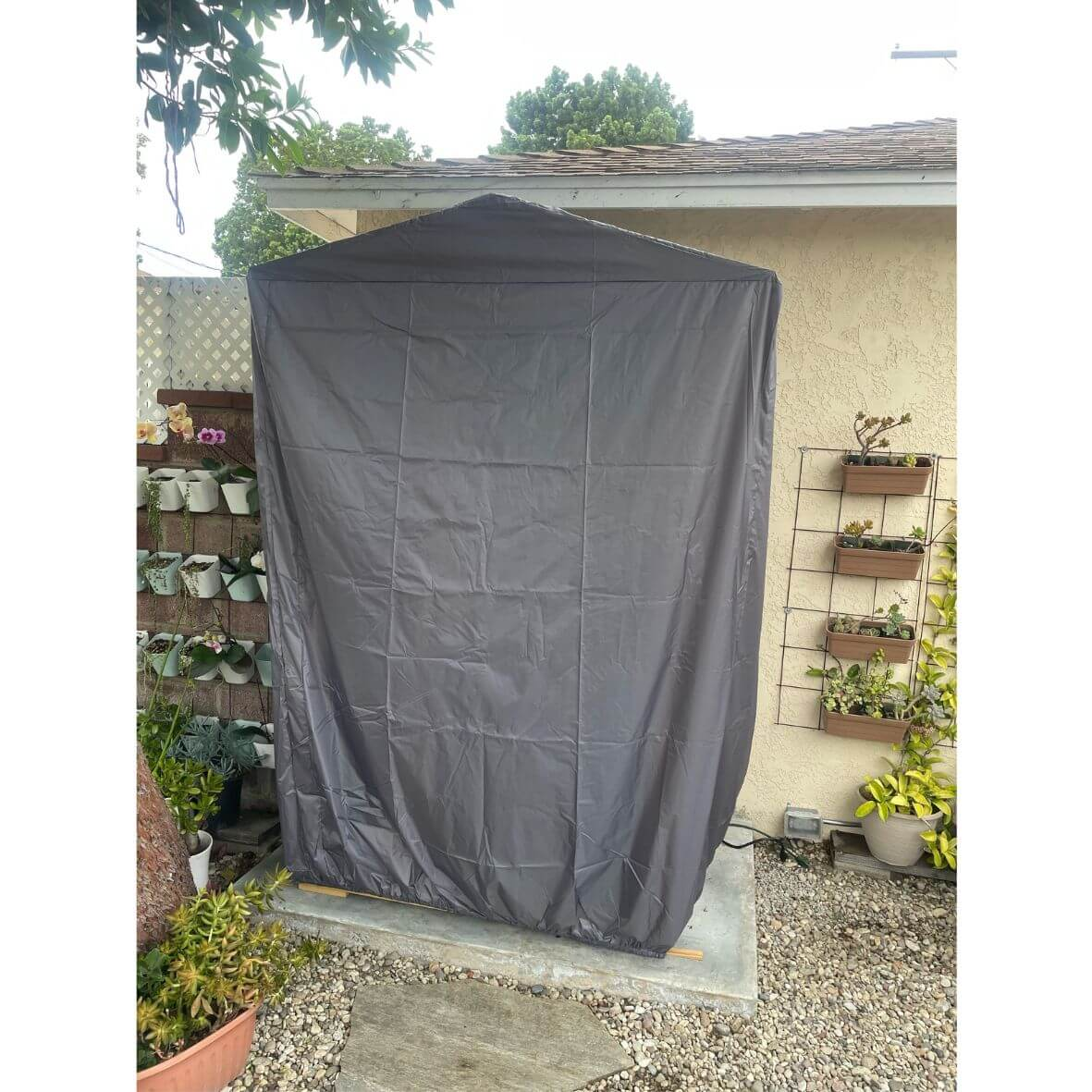 Gray heavyduty outdoor shed cover protecting a structure from elements