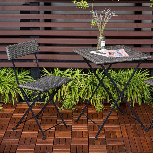 Gray rattan folding bistro chair with black metal frame on wooden deck