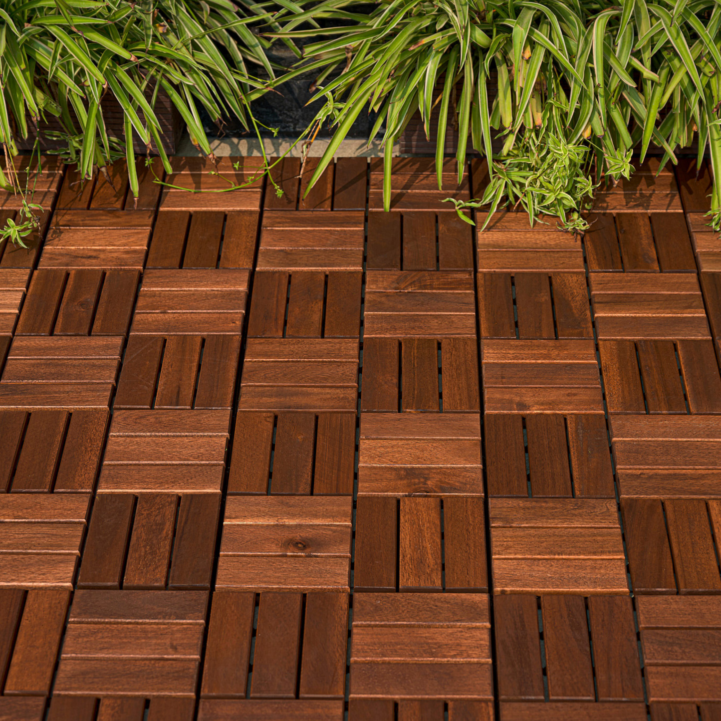 Rich brown hardwood deck tiles arranged in a geometric pattern with lush green foliage above