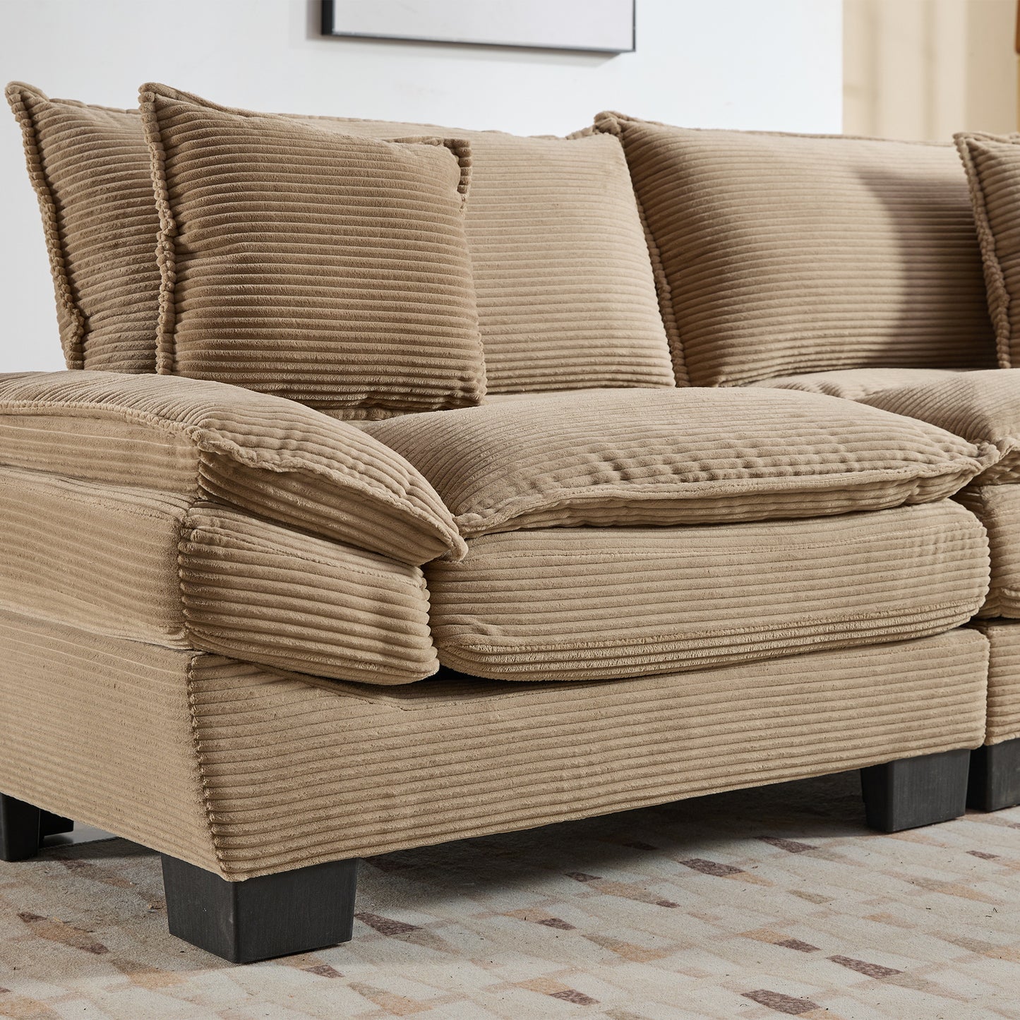 Closeup of plush beige corduroy sofa with wide wales and deep comfortable cushions