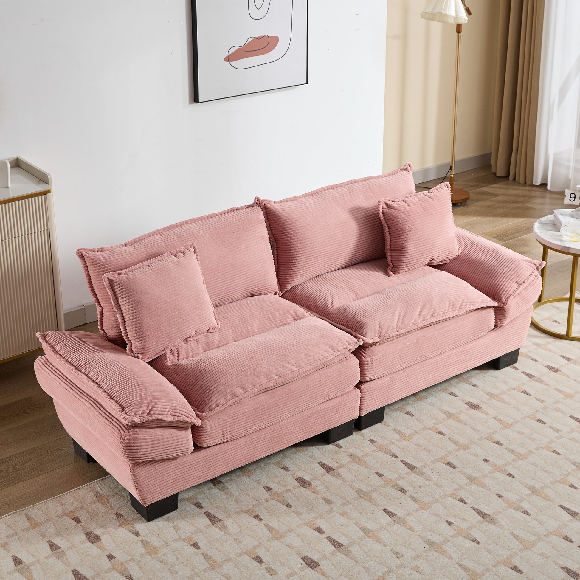 Plush pink corduroy sofa with plush cushions and matching throw pillows