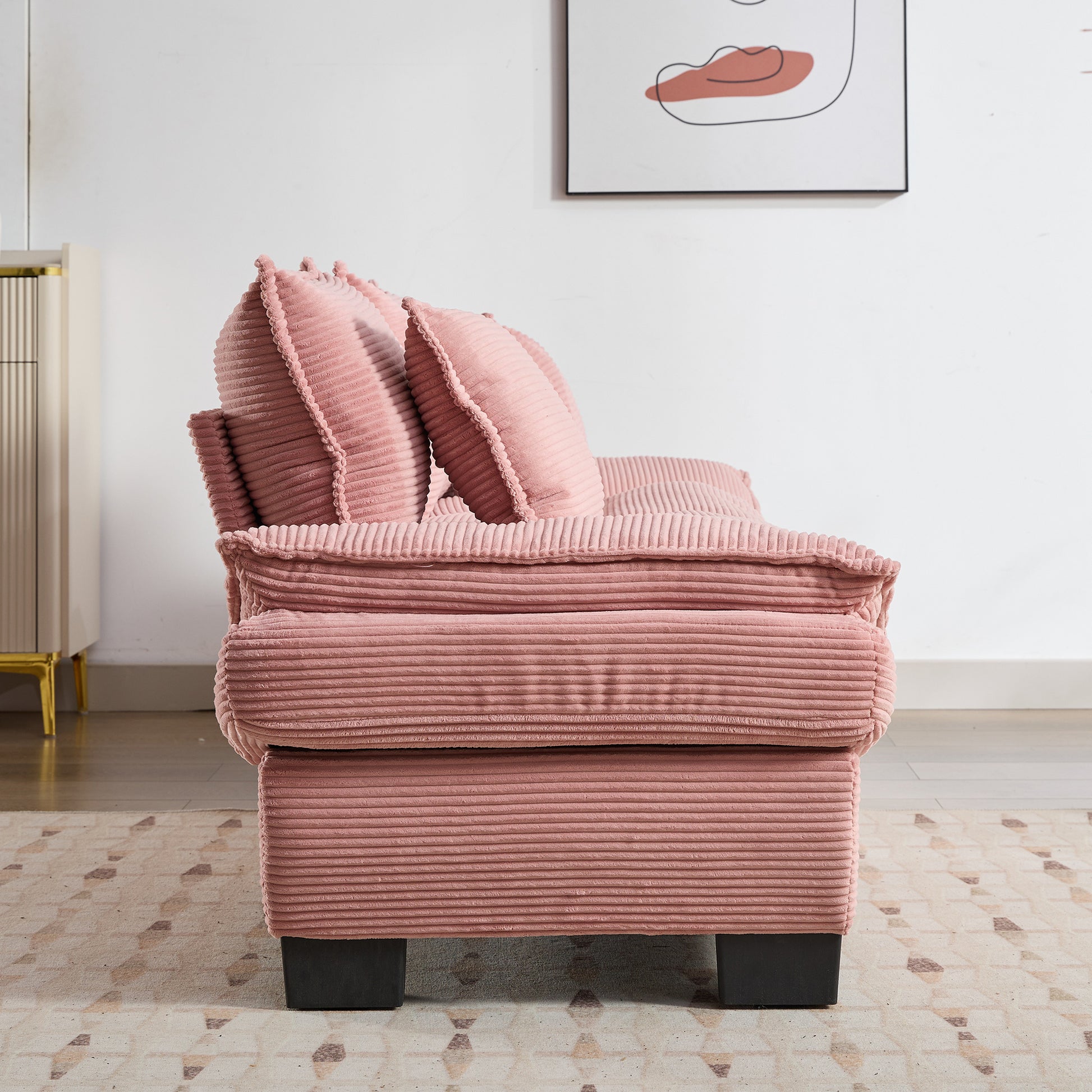 Plush pink corduroy sofa with textured fabric and matching throw pillows perfect for a cozy living room