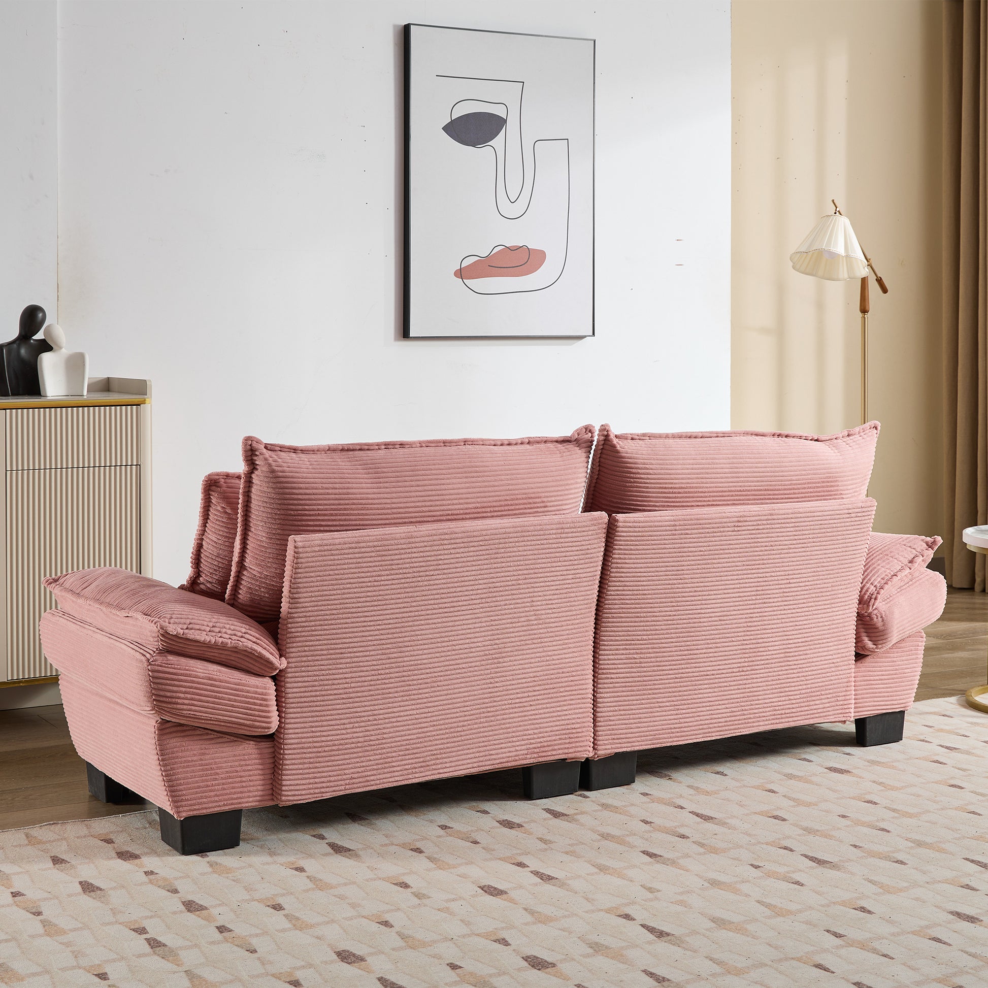 Threeseater pink corduroy sofa with plush cushions perfect for a cozy living room