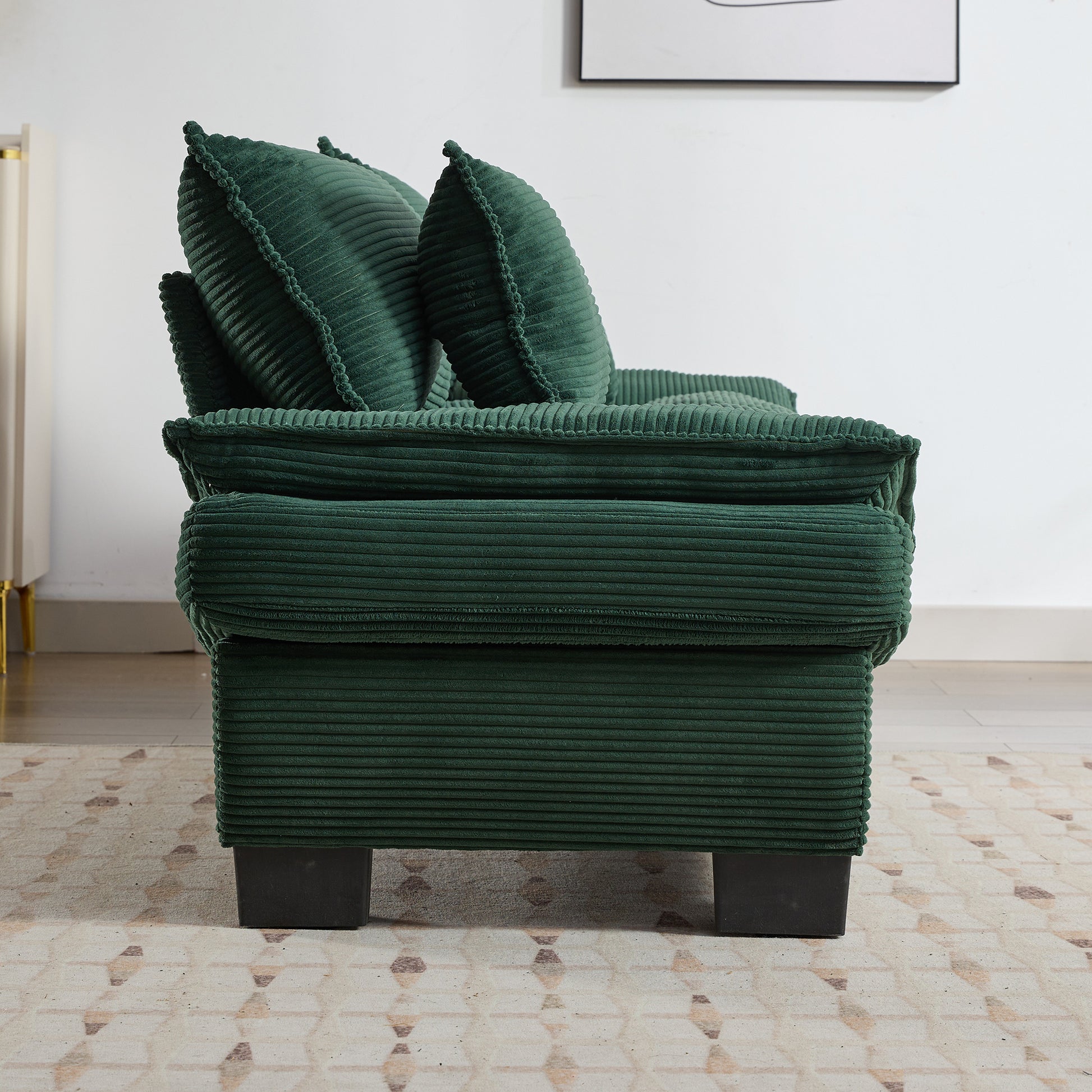 Deep green corduroy sofa with plush cushions offering cozy seating
