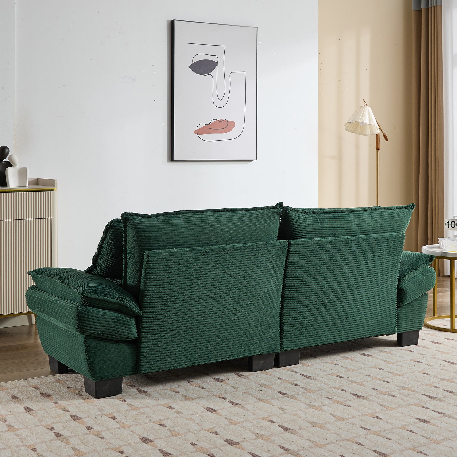 Dark green corduroy sofa with plush cushions and wooden legs ideal for living rooms