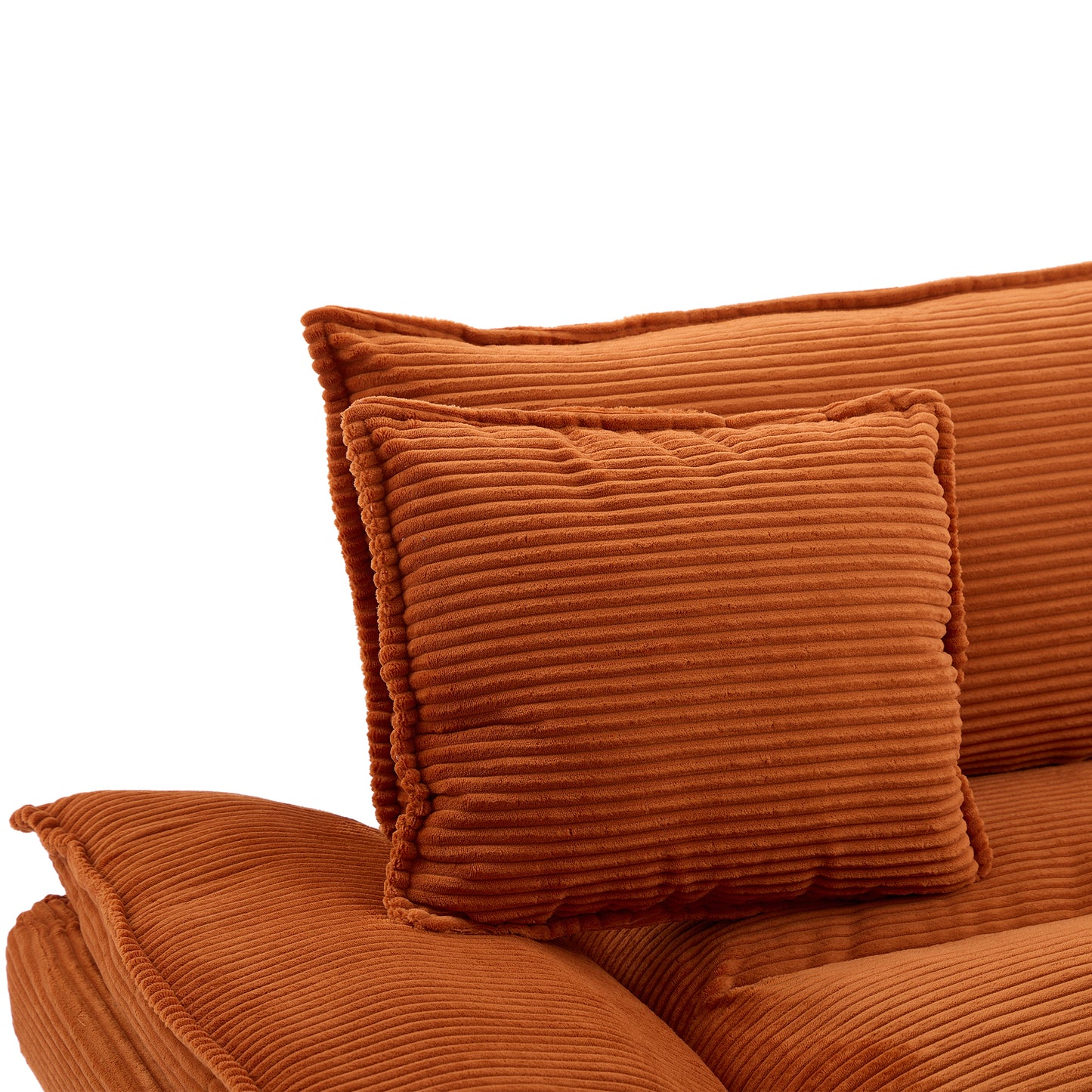Closeup of two rustcolored corduroy throw pillows stacked on a matching sofa cushion