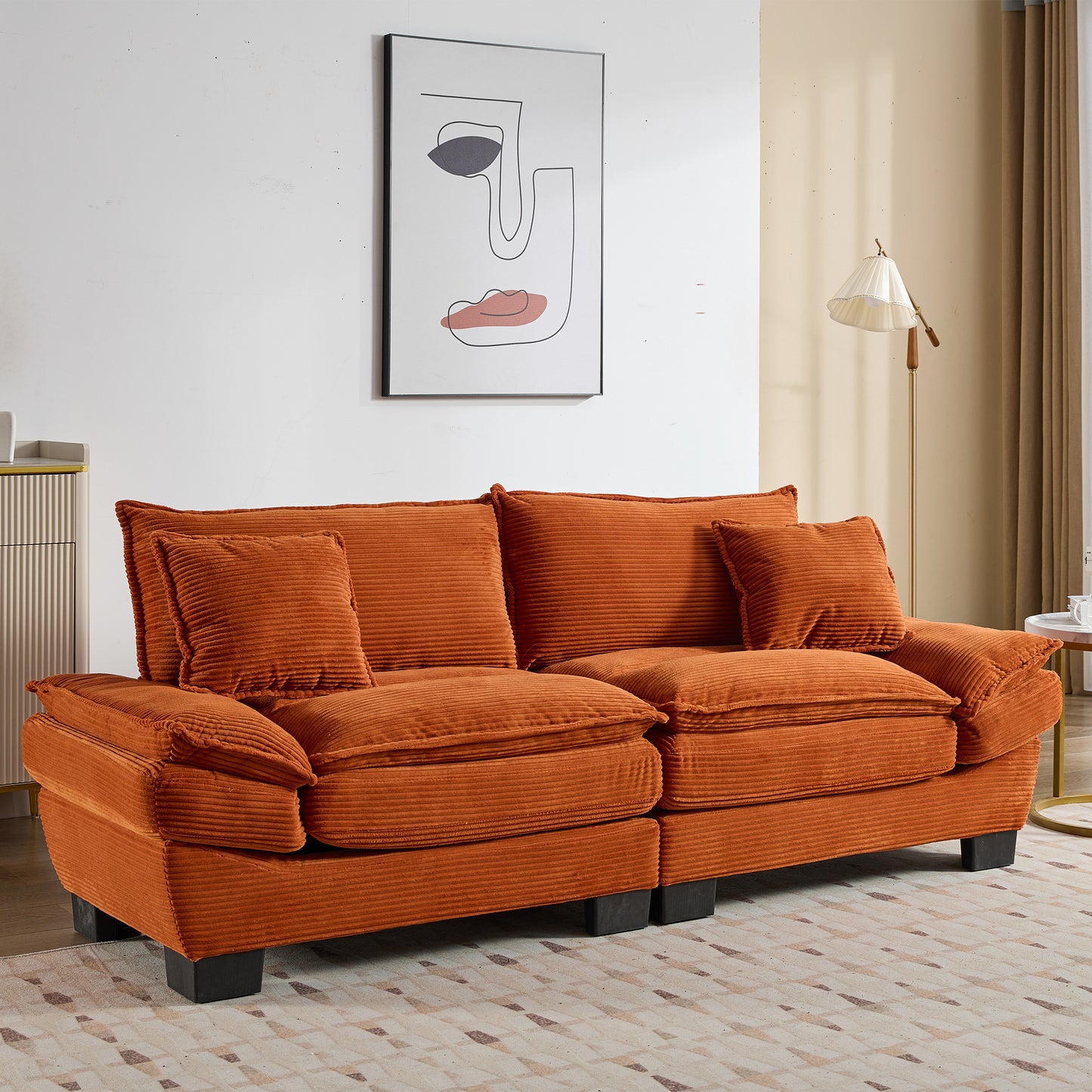 Burnt orange corduroy sofa with plush cushions and minimalist abstract art backdrop