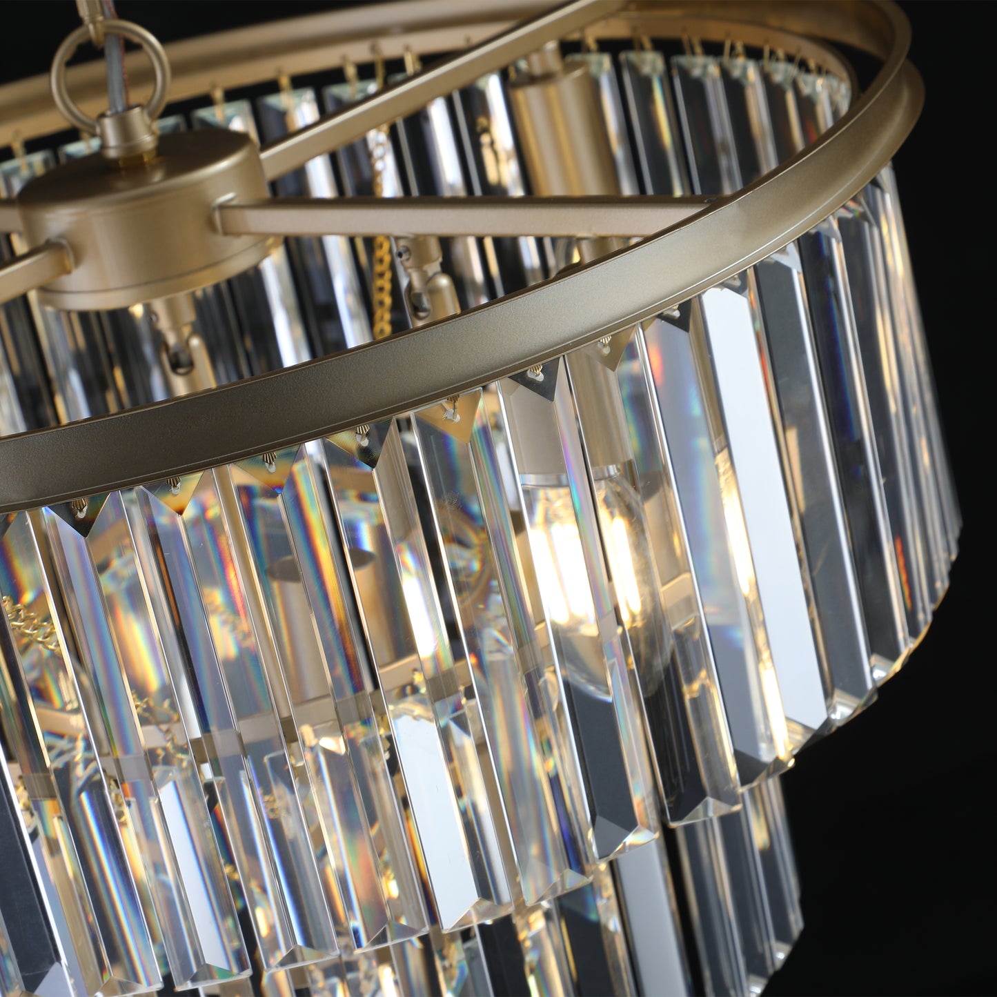 Closeup of a gold chandelier with clear crystal prisms and warm light