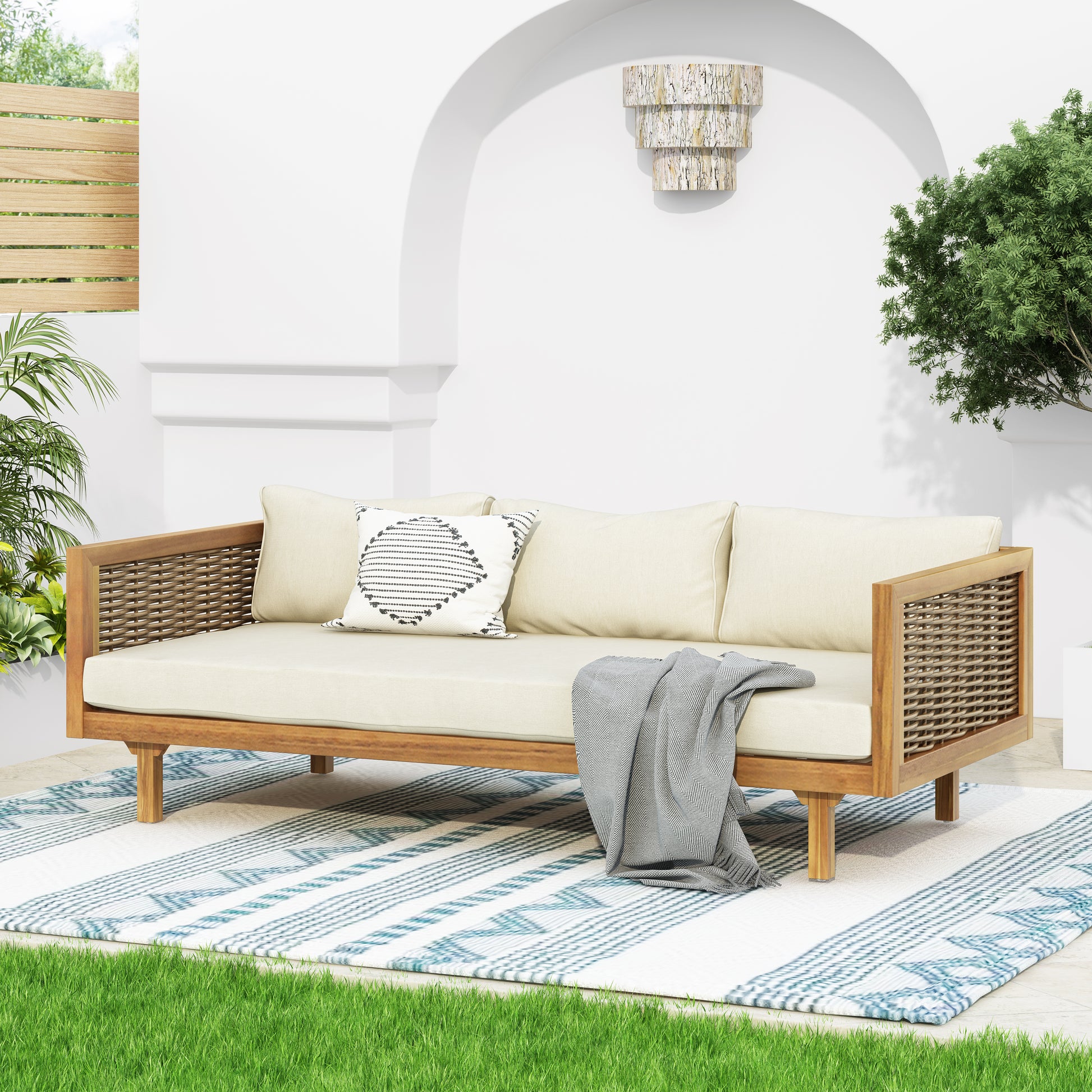 Modern outdoor sofa with woven rattan arms and cream cushions perfect for patio relaxation