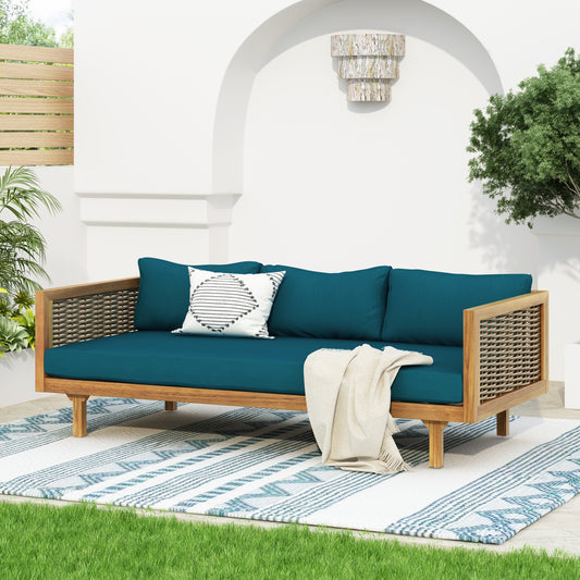 Teal upholstered outdoor daybed with woven sides and wooden frame