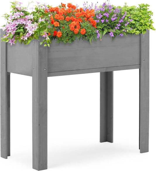 Gray elevated garden planter box filled with pink clematis orange marigolds purple flowers and green foliage