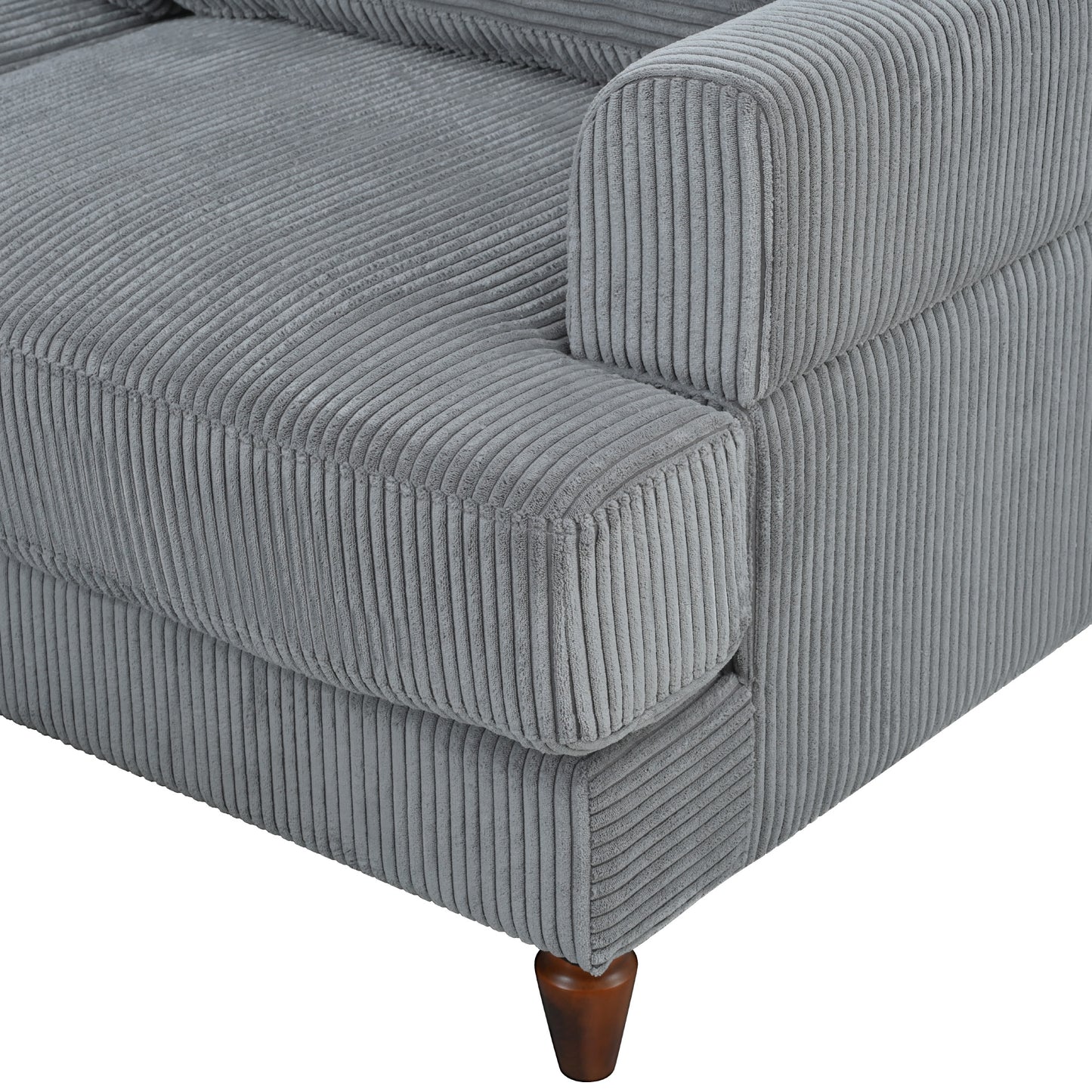 Closeup of a grey corduroy sofa armrest and seat cushion showing ribbed texture